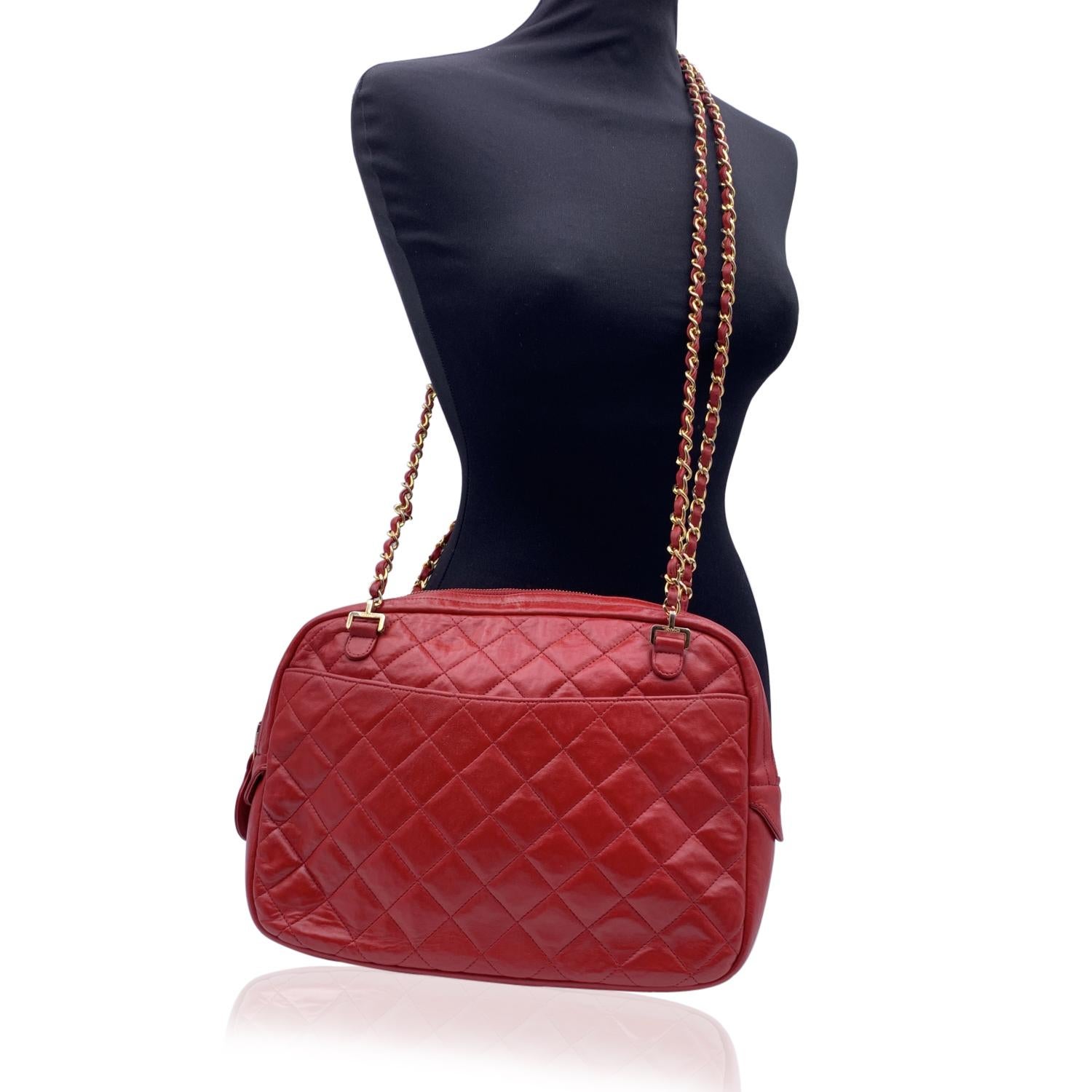 Vintage Chanel Quilted 'Camera Bag' Shoulder Bag in red color from 1991 circa. Features upper zipper closure, CC - CHANEL logo zipper pull, front and rear open compartment and gold metal chain straps with interwoven leather. Red leather lining with