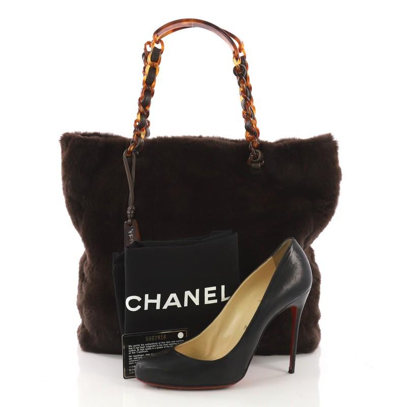 This Chanel Vintage Resin Chain Tote Fur Large, crafted in dark brown fur, features dual leather and tortoise resin chain handles with shoulder rests and black-tone hardware. Its magnetic snap button closure opens to a brown leather interior.