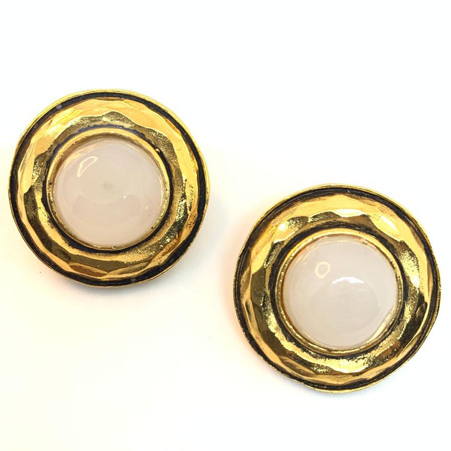 The earrings come from Maison CHANEL. Made of metal gilded with gold leaf, they are round in shape and encircle a ball of mother-of-pearl glass paste.
Made In France
The earrings are vintage clips in very good condition. They have a diameter of 2.8