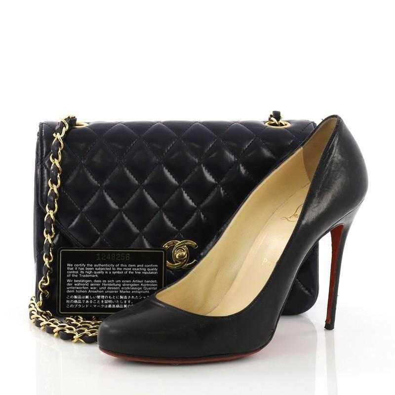 This Chanel Vintage Round Flap Bag Quilted Lambskin Small, crafted in navy lambskin leather, features woven in leather chain link strap and gold-tone hardware. Its CC turn-lock closure opens to a burgundy leather interior with zip and slip pockets.