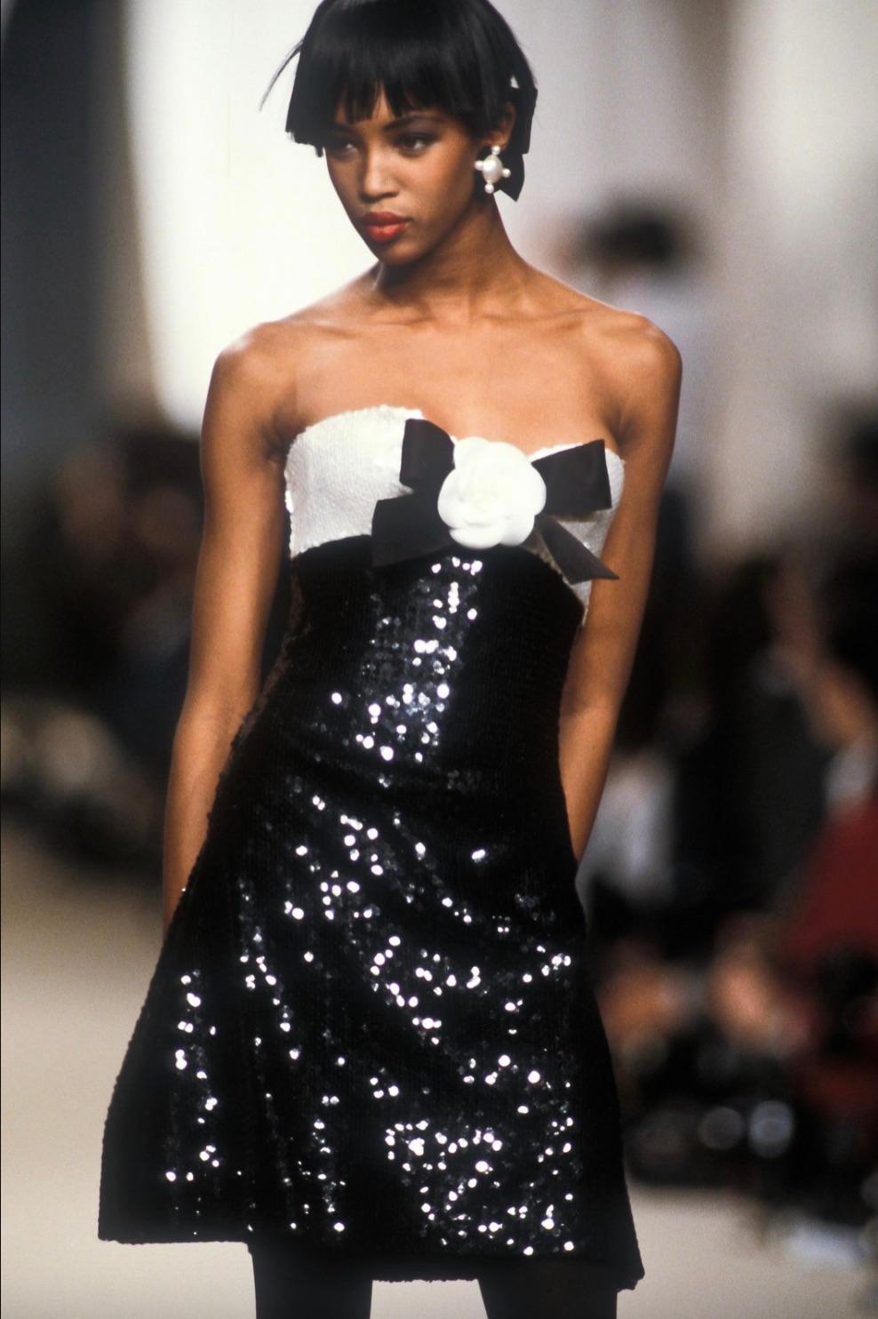 Questo squisito mini abito vintage di Chanel della collezione Primavera/Estate 1987 è un capolavoro di eleganza senza tempo. Il design senza spalline presenta una silhouette aderente ornata interamente da paillettes scintillanti. Il corpetto,