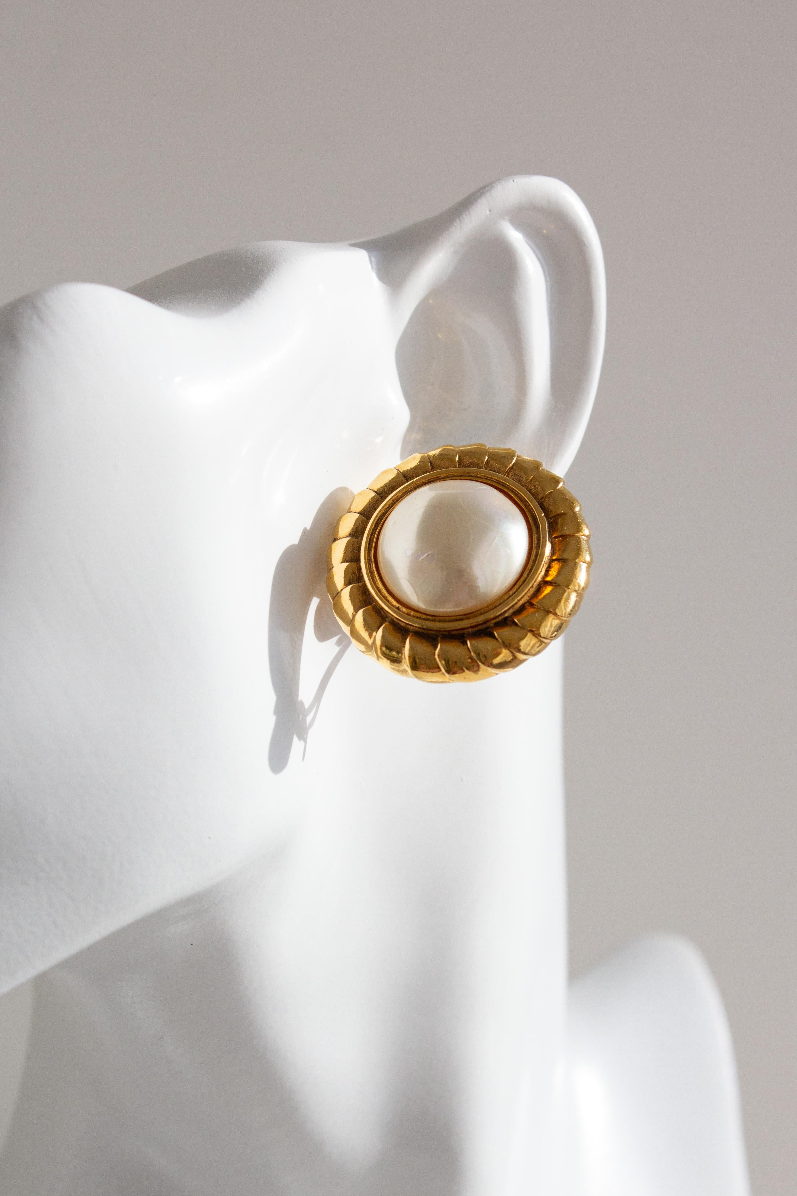 Klassische Vintage-Ohrringe von Chanel aus der Collection'S, Frühjahr/Sommer 1990, aus 24 Karat vergoldetem Metall mit großen cremefarbenen Kunstperlen in einer strukturierten runden Fassung.
Zustand: Sehr guter Vintage-Zustand mit leichter