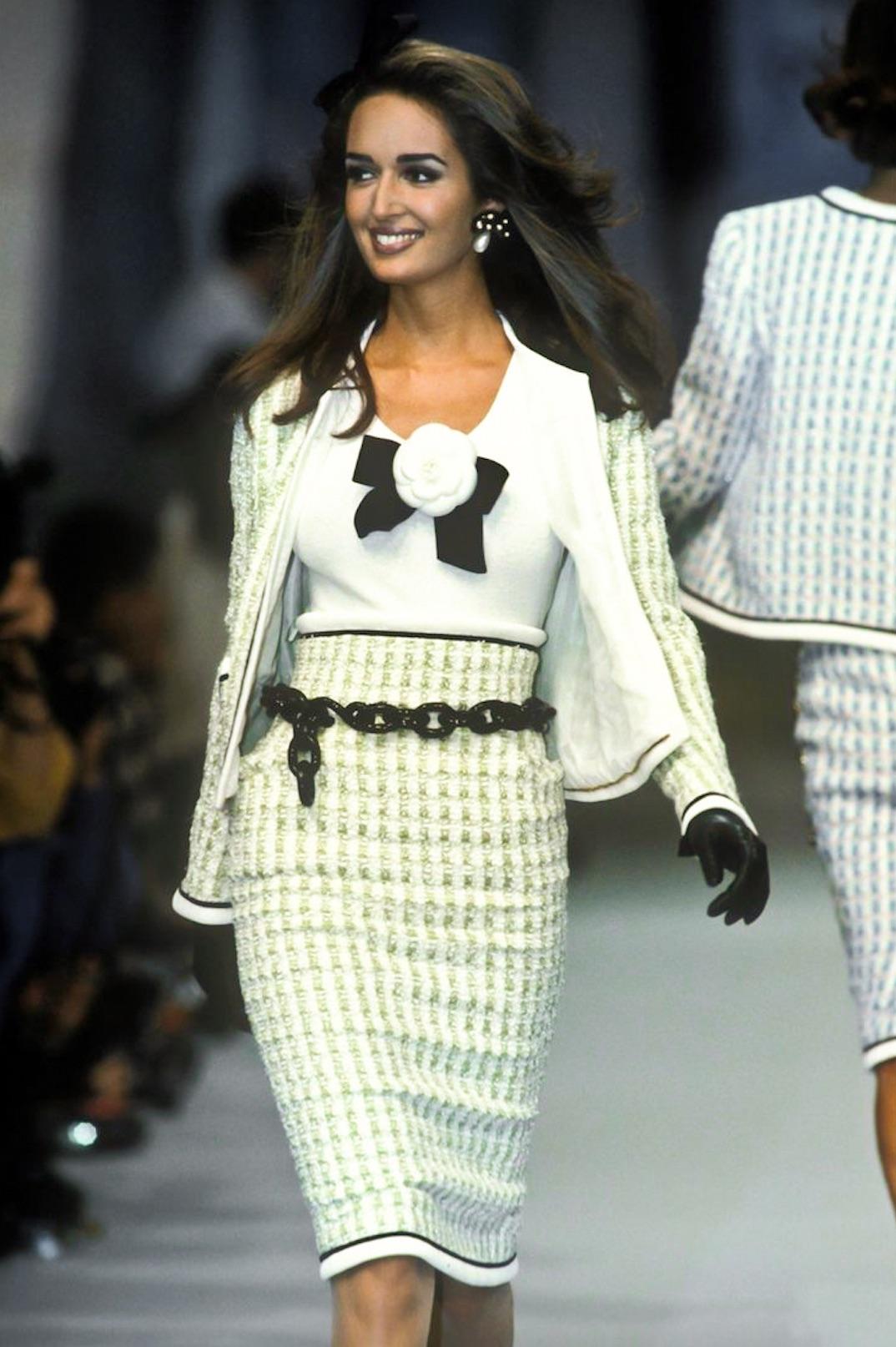 Splendido set a due pezzi della collezione primavera/estate 1992 di Chanel, realizzato in tweed fantasia verde menta e bianco. Classica giacca senza colletto con finiture in maglia a coste bianche e nere, pattine per le tasche e bottoni neri con