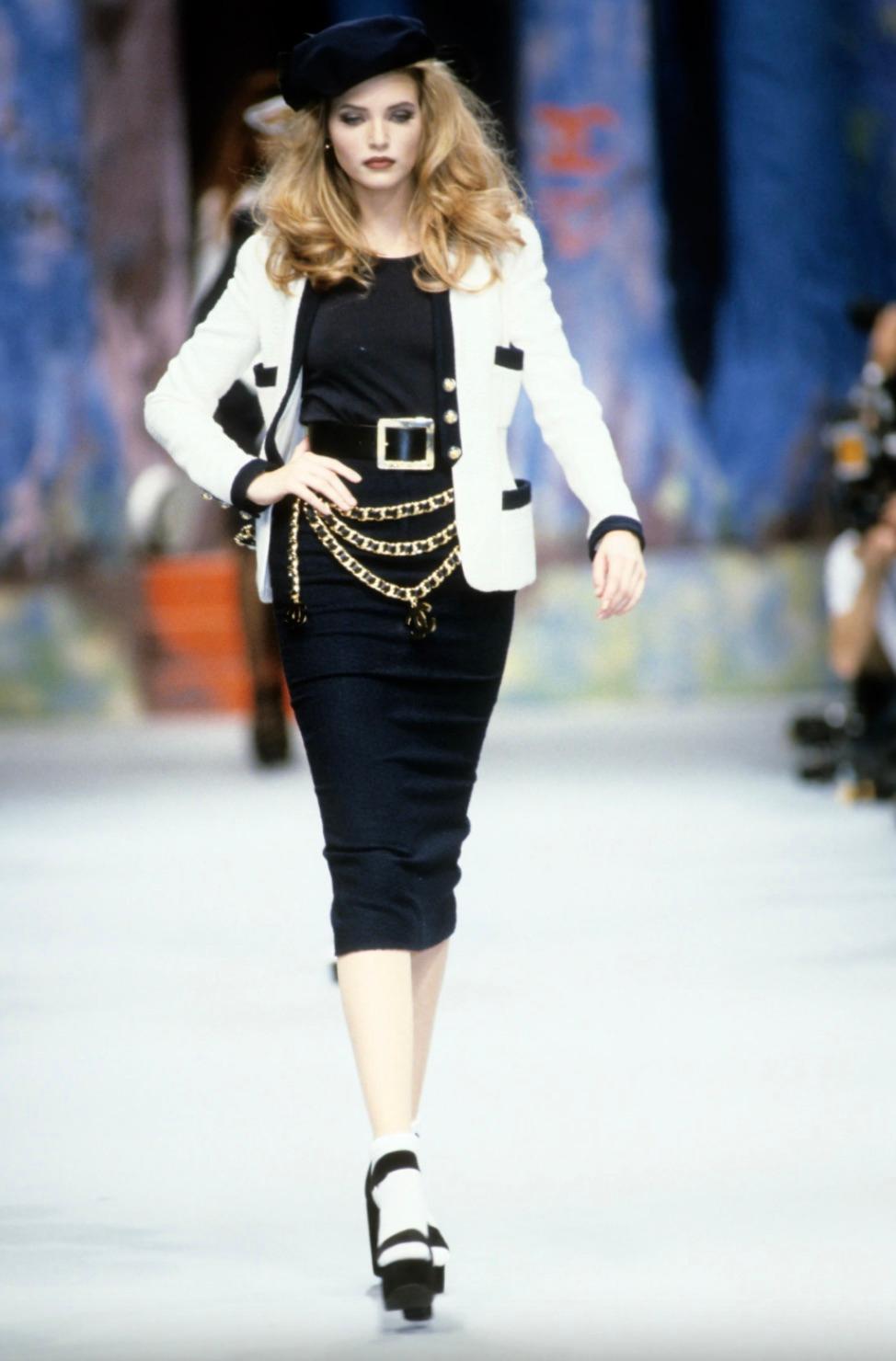 Vintage Chanel Spring/Summer 1992 collection white cotton jacket, a rare piece seen on supermodels Claudia Schiffer and Nadja Auermann. The classic blazer features navy trims, four patch pockets and gorgeous lucite buttons with gold camellia at the