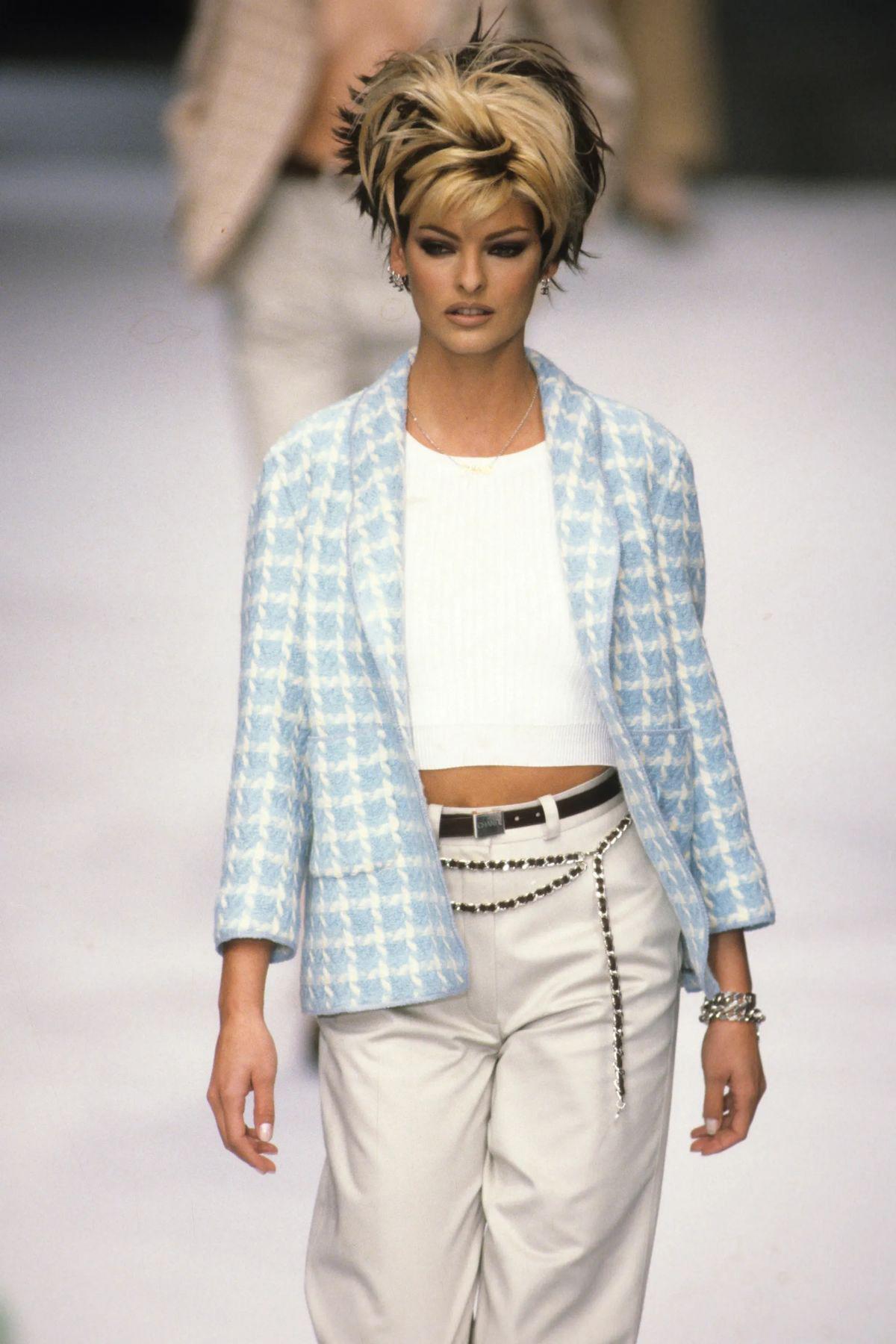 A playful yet iconic piece from the Chanel Spring/Summer 1996 Ready-to-Wear collection, this sky-blue tweed jacket is instantly recognizable. Famously worn by Linda Evangelista on the runway and in 1996 Chanel ad starring Amber Valletta and Shalom