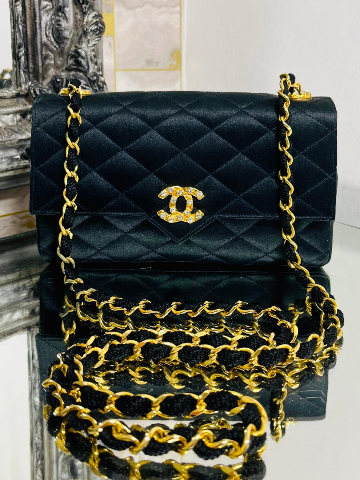 Chanel Vintage Satin Quilted Timeless Bag

De 1986 à 1988. Sac en satin noir à points de diamant avec accessoires en or 24k.

La fermeture tournante avec le logo 'CC' est ornée de cristaux. Même cristal

Les détails de l'Icone se retrouvent sur les