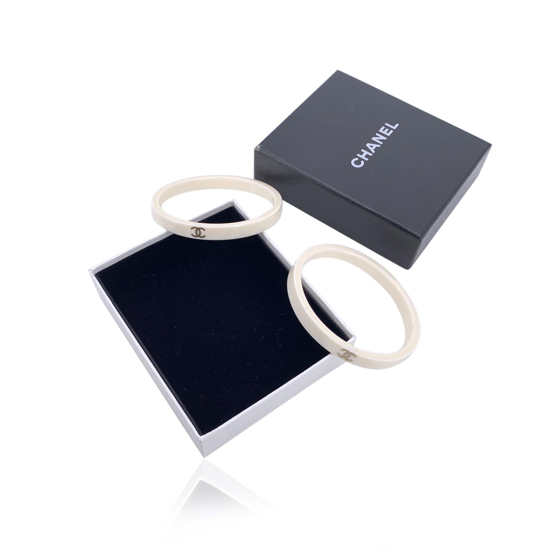 Elevate your accessory game with this chic and playful set of 2 Chanel resin CC logo narrow bangle bracelets. Crafted from white resin, these bangles feature the iconic small CC logos, adding a touch of subtle luxury to your ensemble. The design is