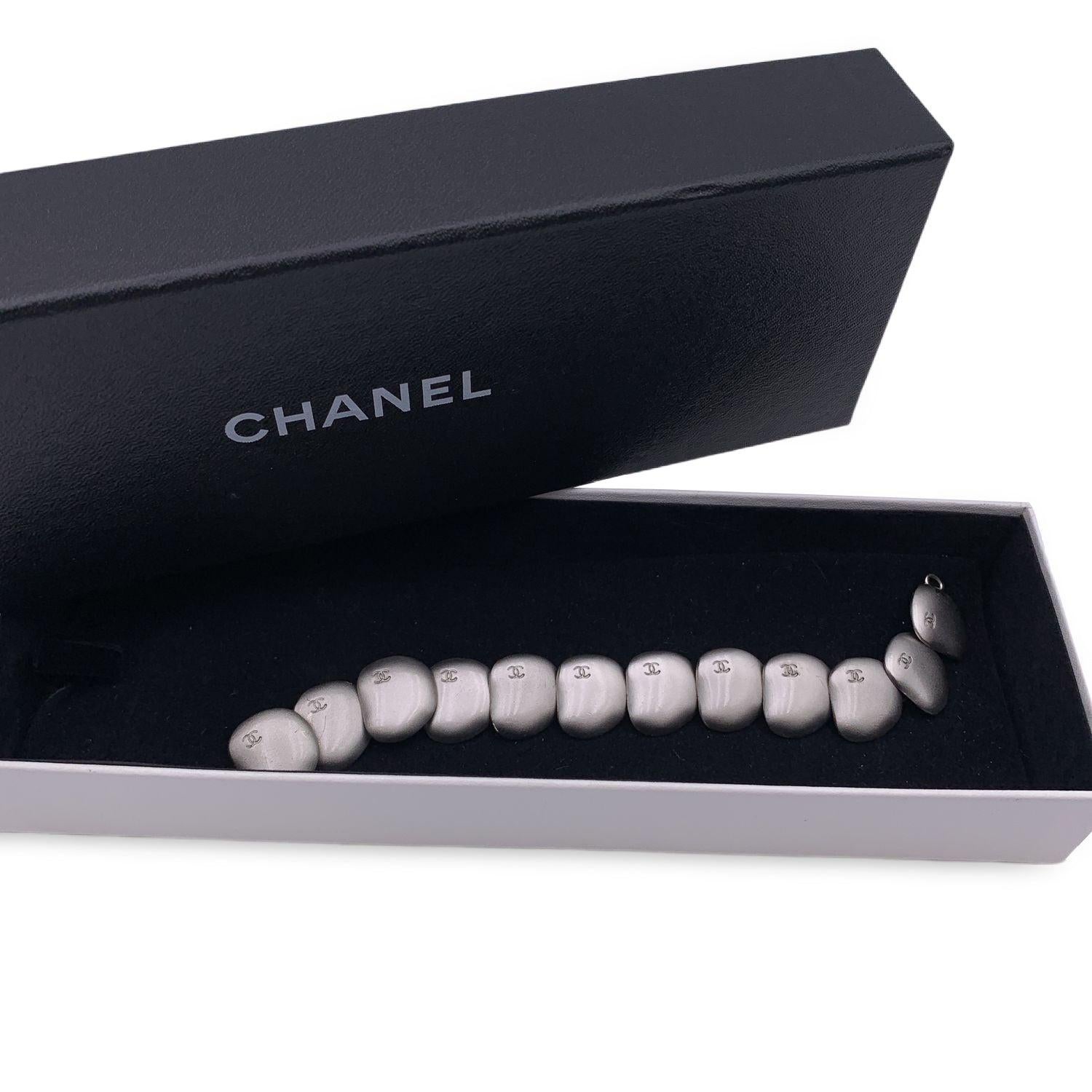 Hübsches Chanel-Armband aus der Herbstkollektion 1999 Aus mattsilbernem Metall mit abgerundeten Schuppen, die sich nacheinander überlappen und so ein hübsches Gliederarmband bilden. CC -CHANEL Logo auf jeder Waage eingraviert. Hakenverschluss.