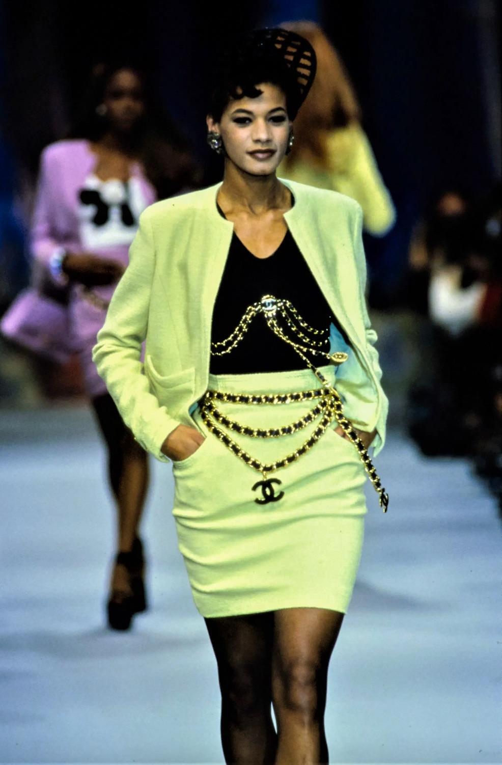 Introducing a rare gem from Chanel's Spring/Summer 1992 collection: an exquisite apple green tweed suit. This ensemble consists of an open-front jacket and a high-waisted knee-length pencil skirt designed to accentuate your figure with stylish