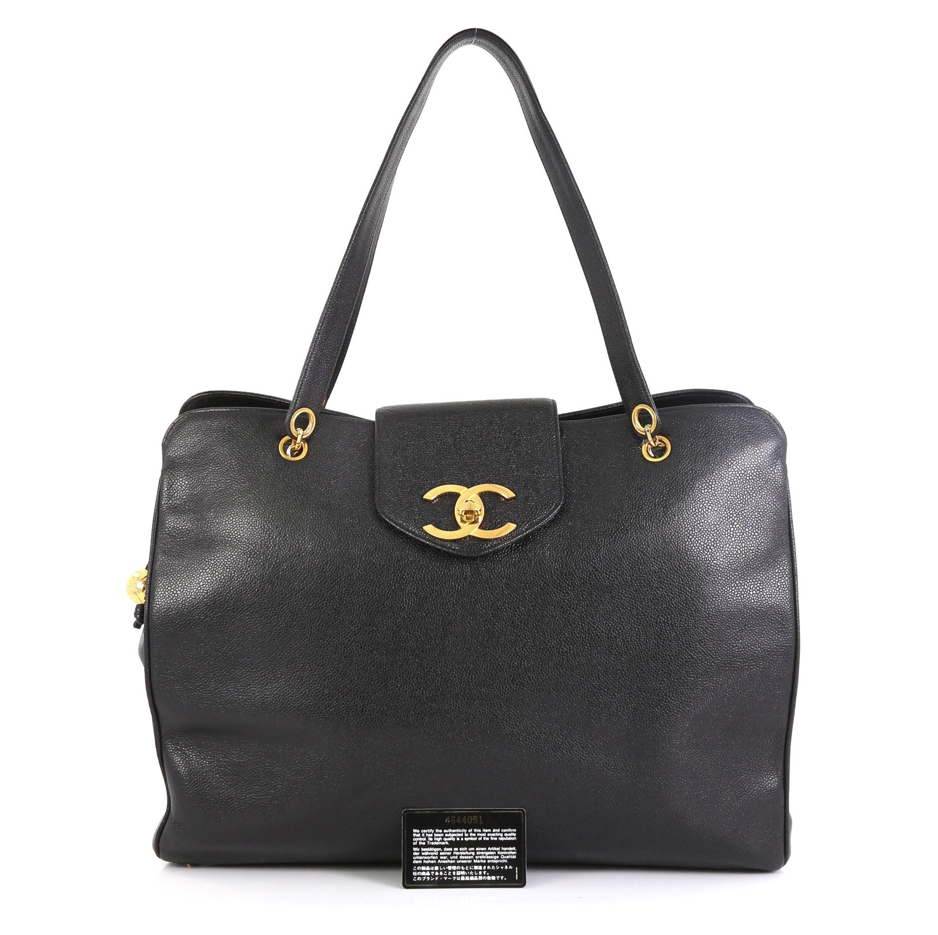 This Chanel Vintage Supermodel Weekender Bag Caviar Large, crafted in black caviar leather, features woven-in leather chain straps with shoulder pads and gold-tone hardware. Its CC turn-lock and zip closures open to a black fabric interior. Hologram
