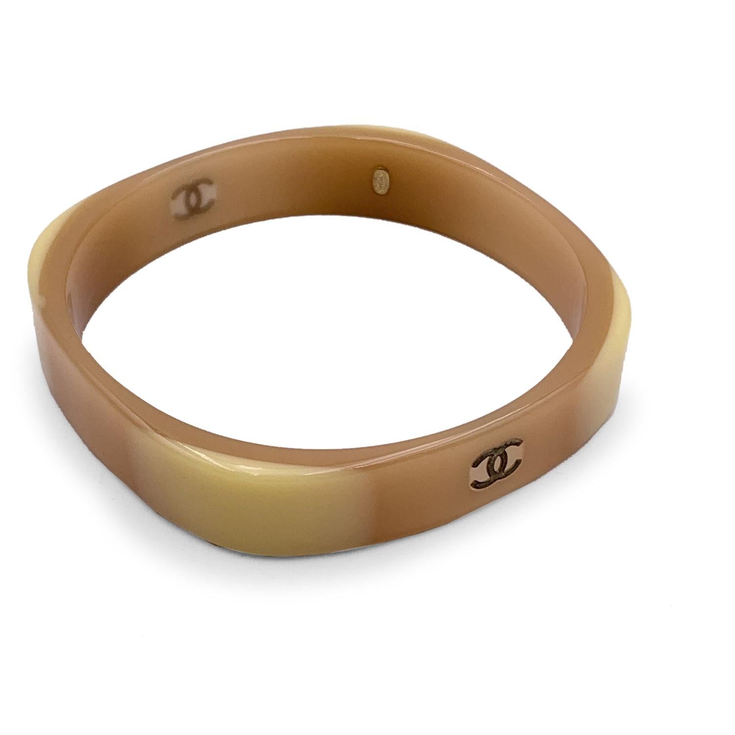 Lovely bangle cuff bracelet by CHANEL. Beige and tan resin with CC logo . Stamped 'Chanel 01 CC A Made in France' internally. Will fit up to approx. 7.75 inches - 19.7 cm wrist. Condition A - EXCELLENT Gently used. Please, look carefully at the