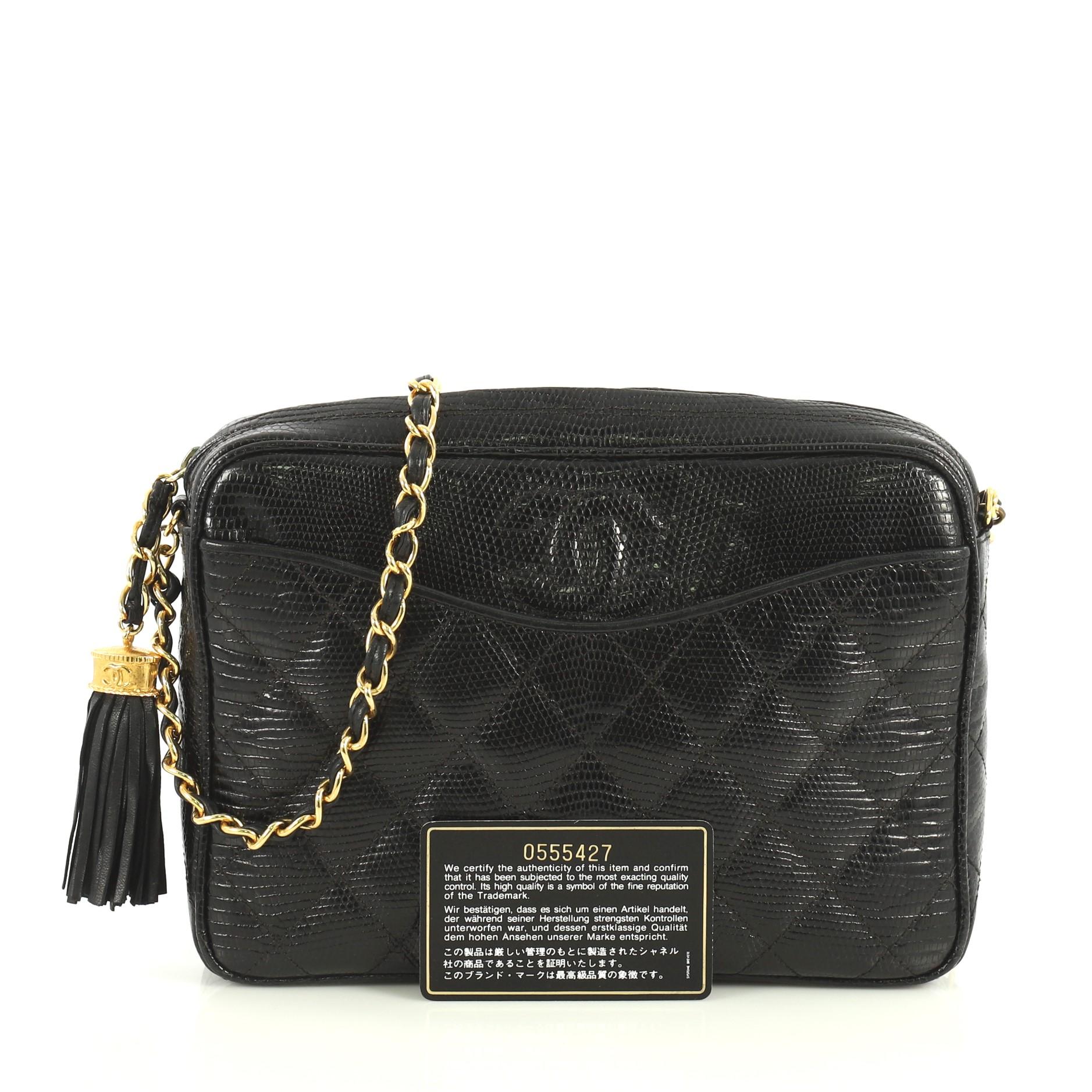 Ce sac photo Chanel Vintage Tassel Lizard Small:: fabriqué en véritable lézard noir:: présente une sangle en chaîne en cuir tressé:: une pochette extérieure:: des pampilles latérales et des éléments en métal doré. Sa fermeture zippée s'ouvre sur un