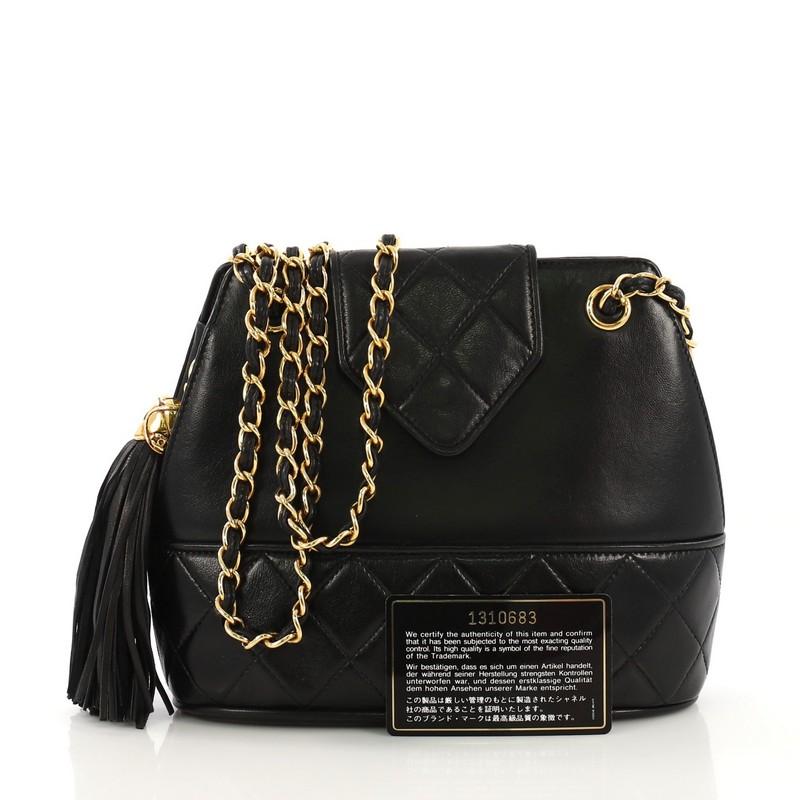 This Chanel Vintage Tassel Shoulder Bag Leather Small, crafted from black leather, features woven-in leather chain strap, tassel charm, and gold-tone hardware. Its magnetic snap closure opens to a black leather interior with zip pocket. Hologram