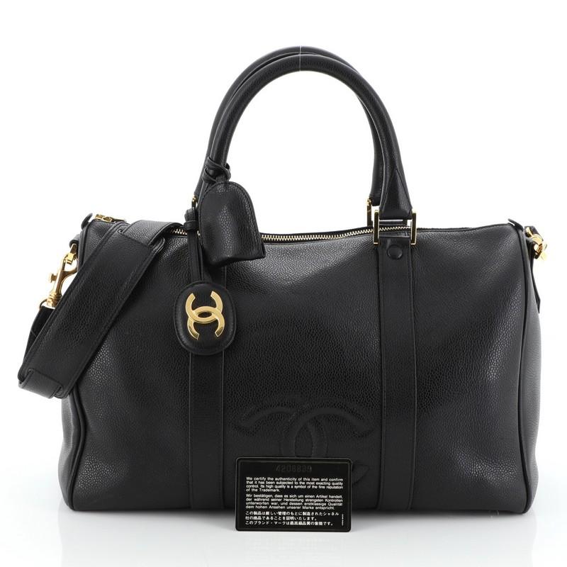 This Chanel Vintage Timeless Boston Bag Caviar Medium, crafted in black caviar leather, features dual rolled leather handles and gold-tone hardware. Its zip closure opens to a black fabric interior with zip and slip pockets. Hologram sticker reads: