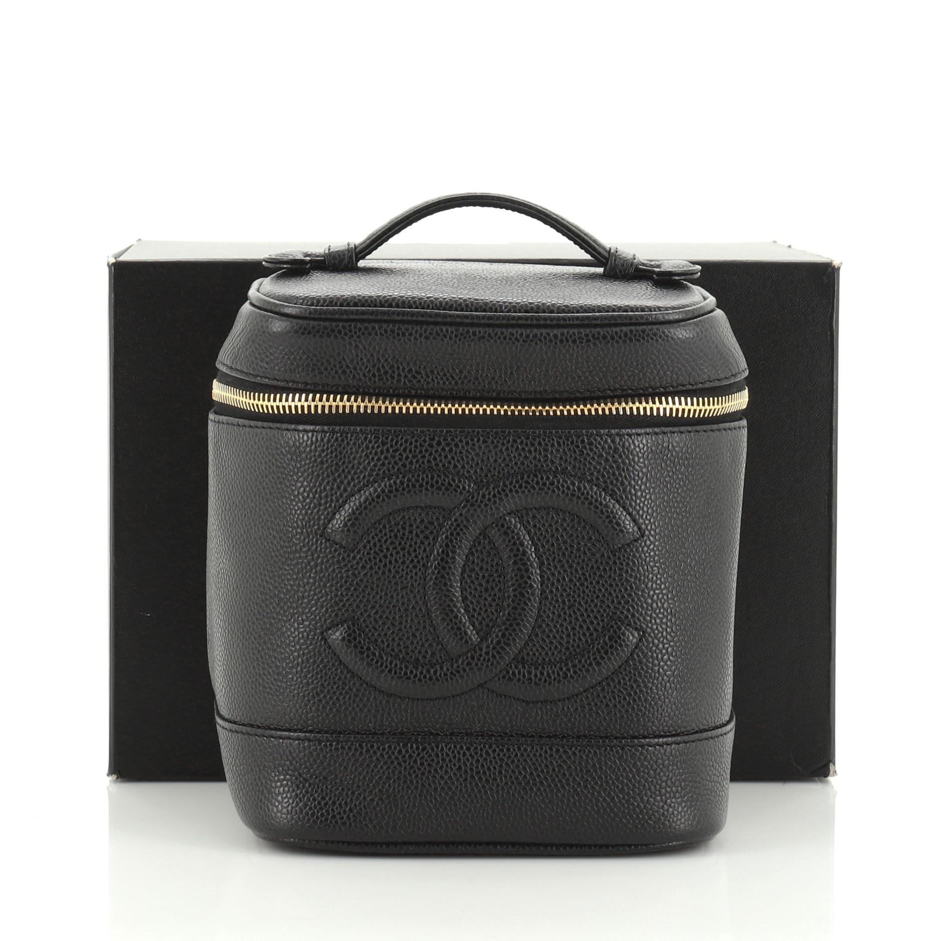 This Chanel Vintage Timeless Cosmetic Case Caviar Tall, crafted in black caviar leather, features a single loop top handle, CC logo at the center and aged gold-tone hardware. Its zip-around closure opens to a black leather interior with slip pocket.