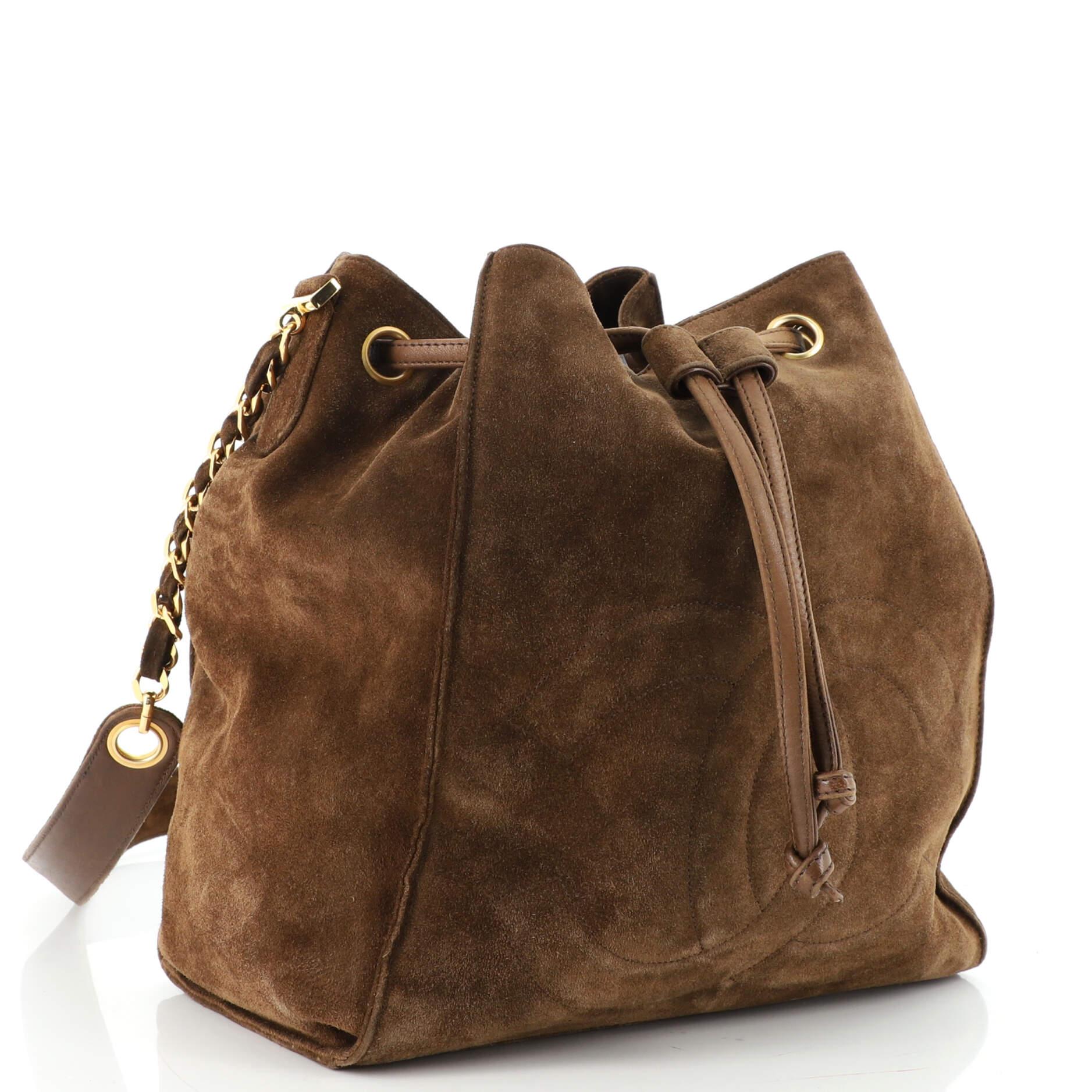 Condition: Good. Discoloration and wear on exterior and on pochette, moderate balding on handle, opening trim, exterior edges. Peeling on drawstring and underneath handle, scratches and discoloration on hardware.
Accessories: No