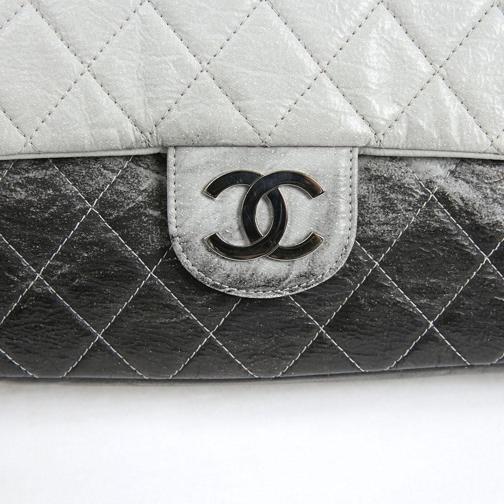 Collector. Vintage Chanel Timeless handbag in semi-patent leather in black and gray quilted leather.
This bag is in very good condition. under the flap there is a trace of pen (picture)
It does not have a double flap.  It closes with a snap.
It is