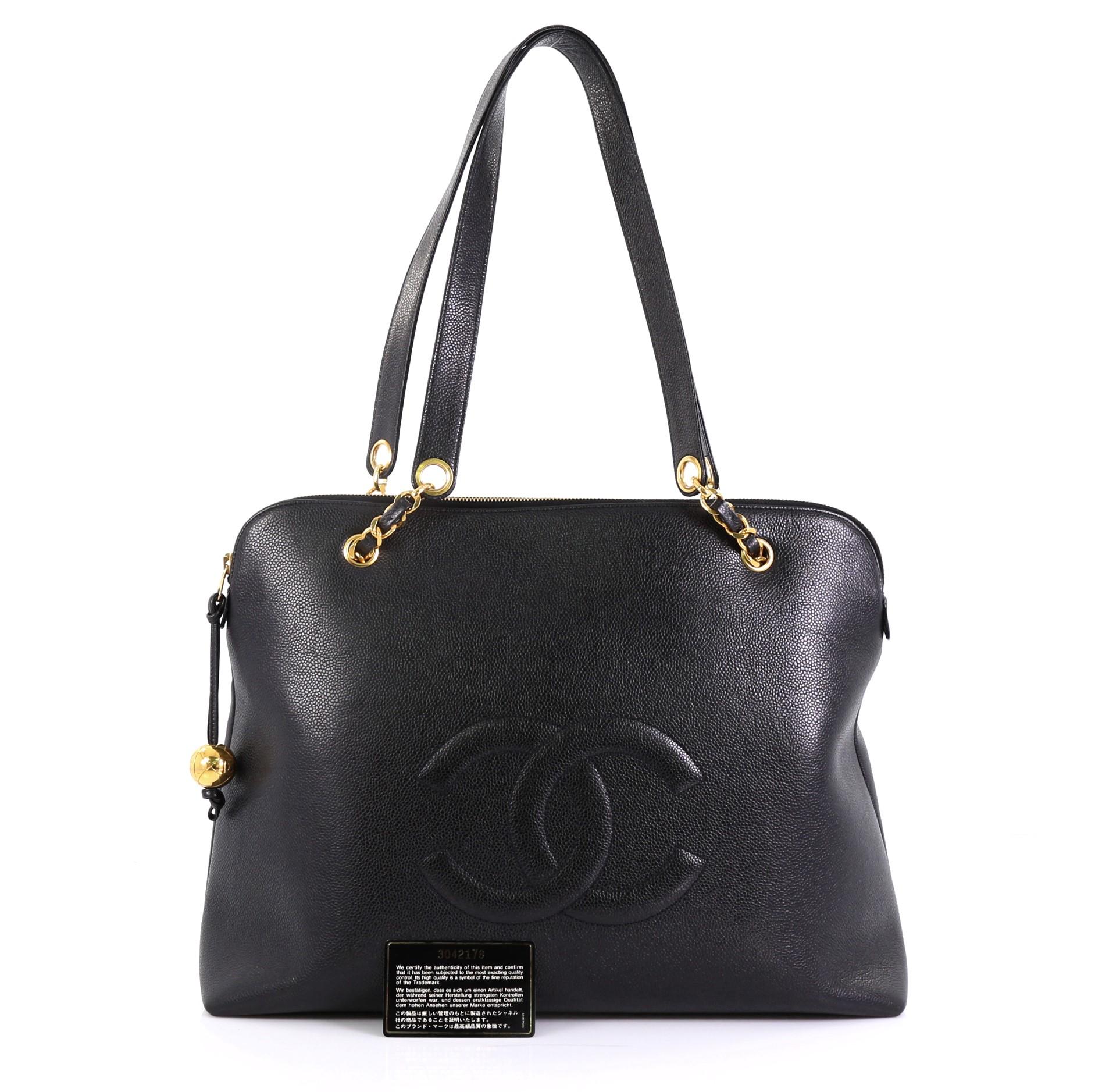 This Chanel Vintage Timeless Zip Tote Caviar Large, crafted from black caviar leather, features woven-in leather chain straps with shoulder pads, CC stitched logo at front, and gold-tone hardware. Its zip closure opens to a black leather interior