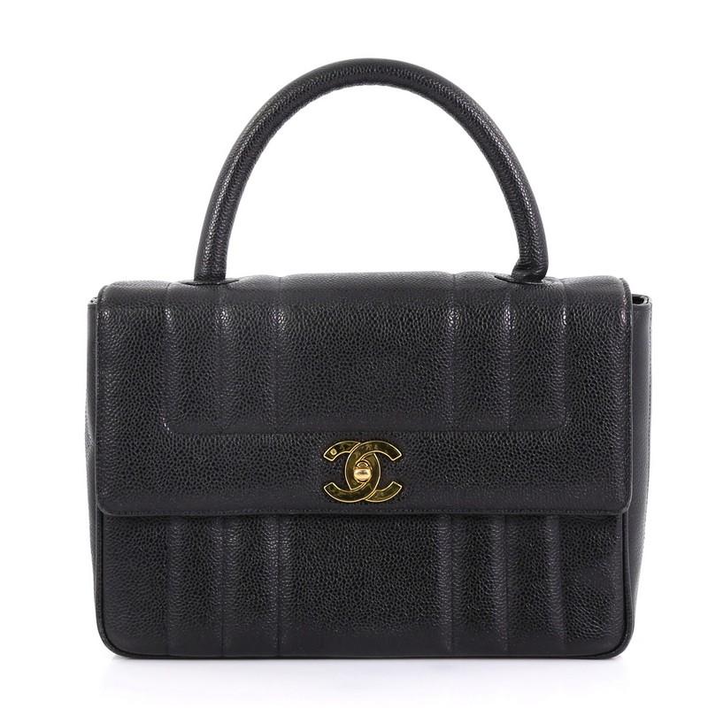 This Chanel Vintage Top Handle Bag Vertical Quilt Caviar Medium, crafted in black vertical quilted caviar leather, features rolled top handle and gold-tone hardware. Its CC turn-lock closure opens to a black leather interior with side zip and slip