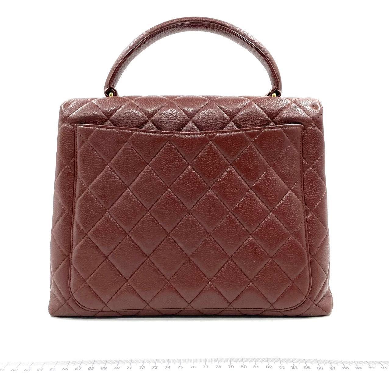 Chanel Vintage Top Handle Kelly Dark Caramel Flap Bag Caviar Leather 24k Gold Plated Hardware, 1996-1997
 These are professional photos of the actual bag.
 Unleash your inner icon with this exquisite Vintage Chanel Dark Caramel Quilted Caviar Top