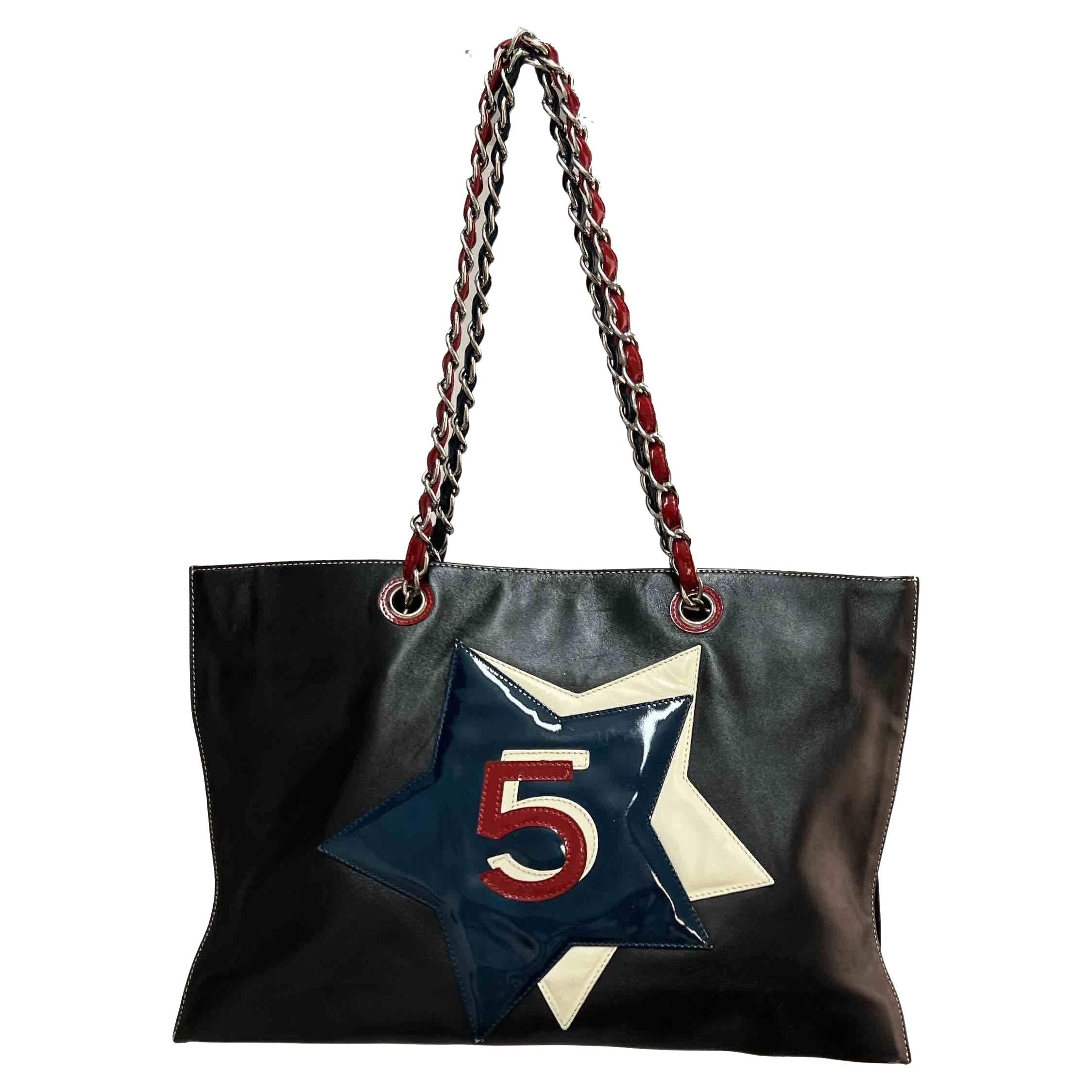 Vintage CHANEL tote bag in black, blue, white, red Leather.  Inside : 2 separate storage bellows. Magnetic closure. Double colors for the handles, one blue and one red.
The hardware is in palladium-plated silver metal.
In good condition.
Made in