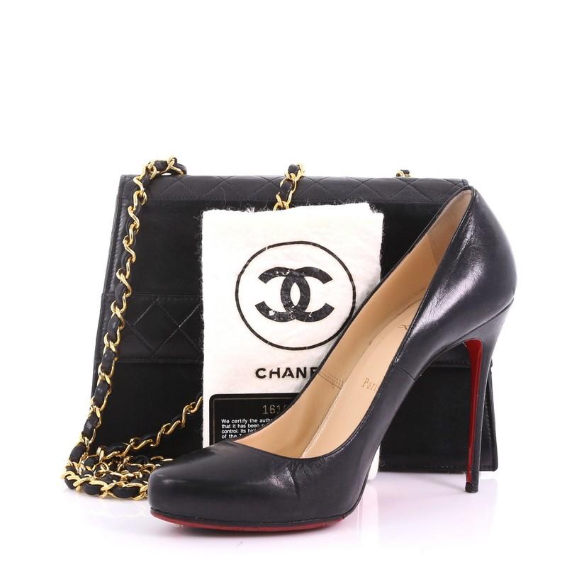 This Chanel Vintage Trapezoid CC Flap Bag Leather Small, crafted in black leather, features woven-in leather chain strap, exterior back slip pocket, protective base studs, and gold-tone hardware. Its turn-lock closure opens to a burgundy leather