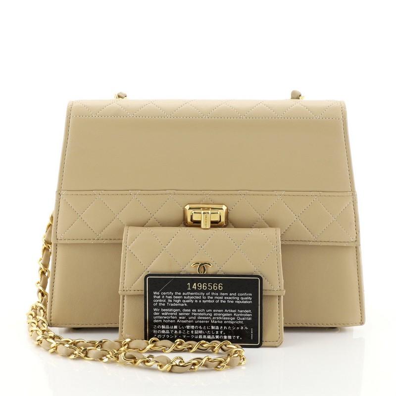 This Chanel Vintage Trapezoid CC Flap Bag Leather Small, crafted in neutral leather, features woven-in leather chain strap, exterior back slip pocket, protective base studs and gold-tone hardware. Its turn-lock closure opens to a neutral leather