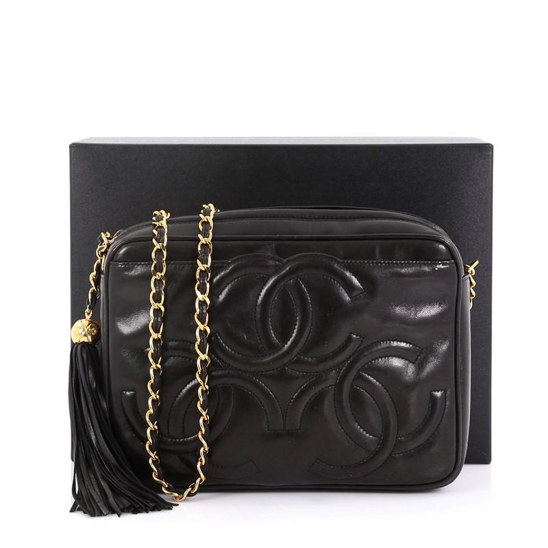 This Chanel Vintage Triple CC Camera Bag Leather Medium, crafted from black leather, features woven-in leather chain strap, exterior front slip pocket with triple stitched CC logo, and gold-tone hardware. Its zip closure opens to a black leather
