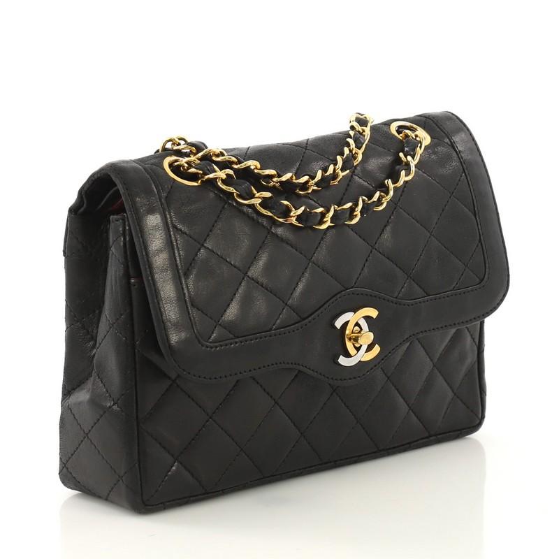 This Chanel Vintage Two-Tone CC Flap Bag Quilted Lambskin Small, crafted from black quilted lambskin leather, features woven-in leather chain straps, exterior back slip pocket, and gold-tone hardware. Its CC turn-lock closure opens to a burgundy