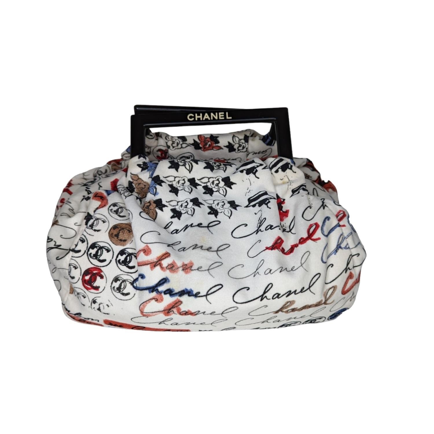 This stunning top handle bag is crafted of off-white velvet with multicolor Camellia Accent Flower Print. The handbag features black acrylic top handles and a black CC medallion zipper pull. The top zipper opens to black fabric interior with a