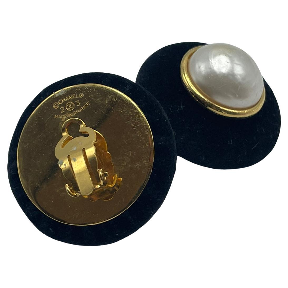 Chanel clip-on earrings in velvet. This one-of-a-kind set of Chanel earrings has a pearl in the middle encircled by a thin gold-plated line and velvet surrounding the gold line. With Chanel's original stamps. Made in France. Excellent workmanship