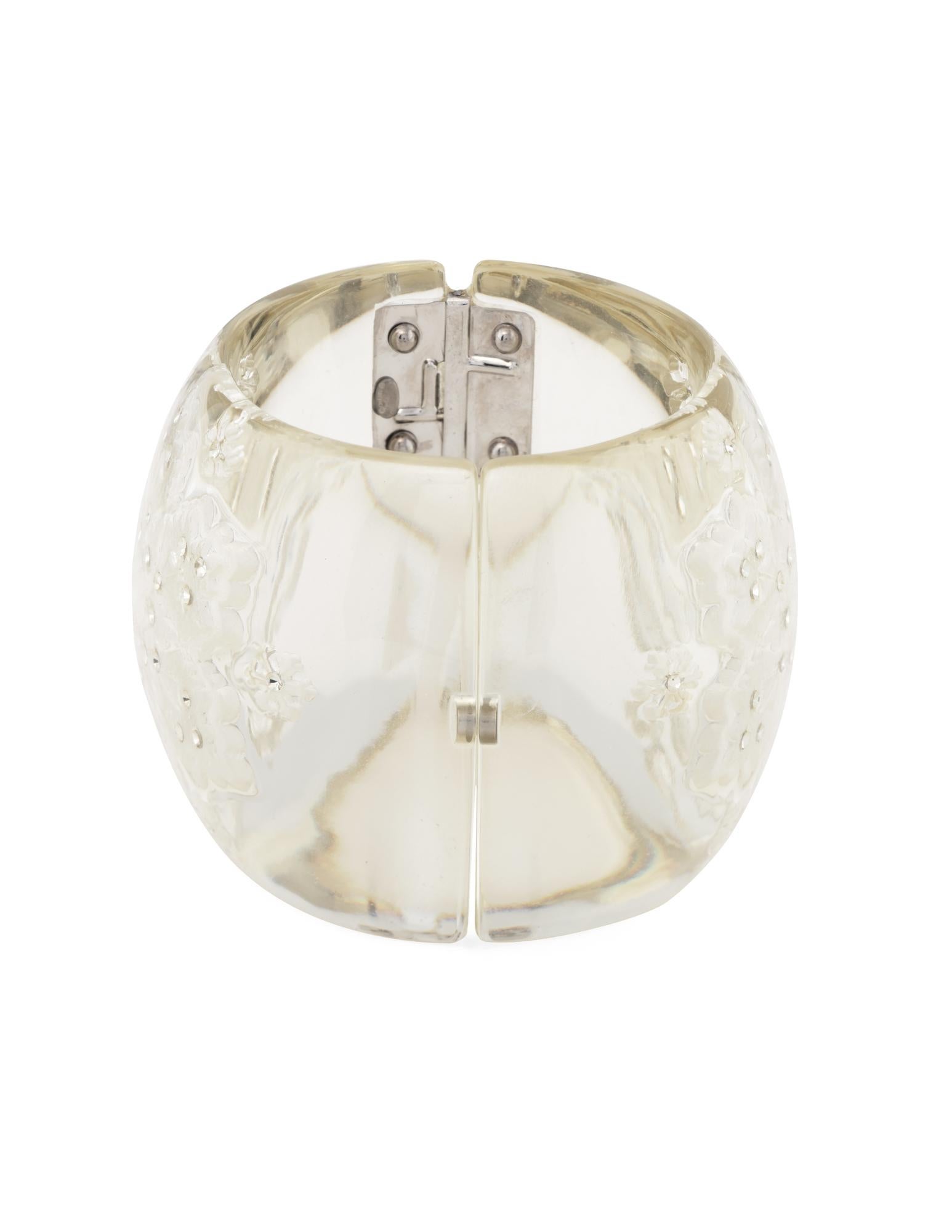 Vintage Chanel Lucite snowflake wide cuff (circa 2005). 

The wide 2 inch cuff features a snowflake design set with rhinestone crystals. The cuff is set with a secure double-hinged design to easily slip on and off the wrist. Also included is a