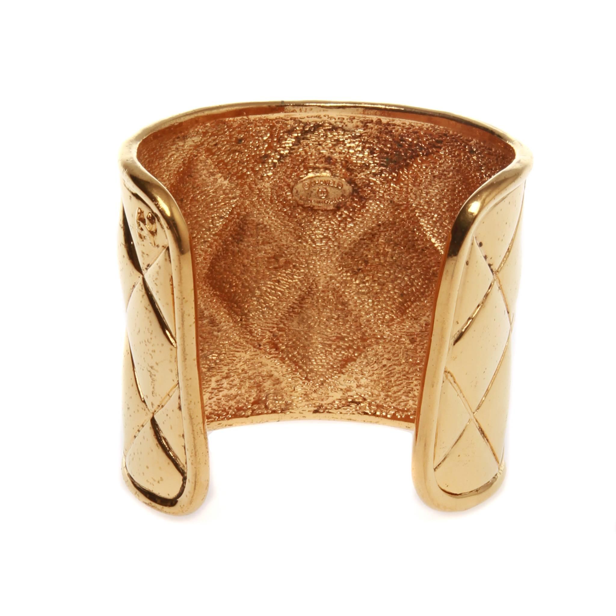 Chanel vintage open cuff featuring a quilt look design in gold-tone metal. Interlocking CC in one corner and brand stamp on inner face.