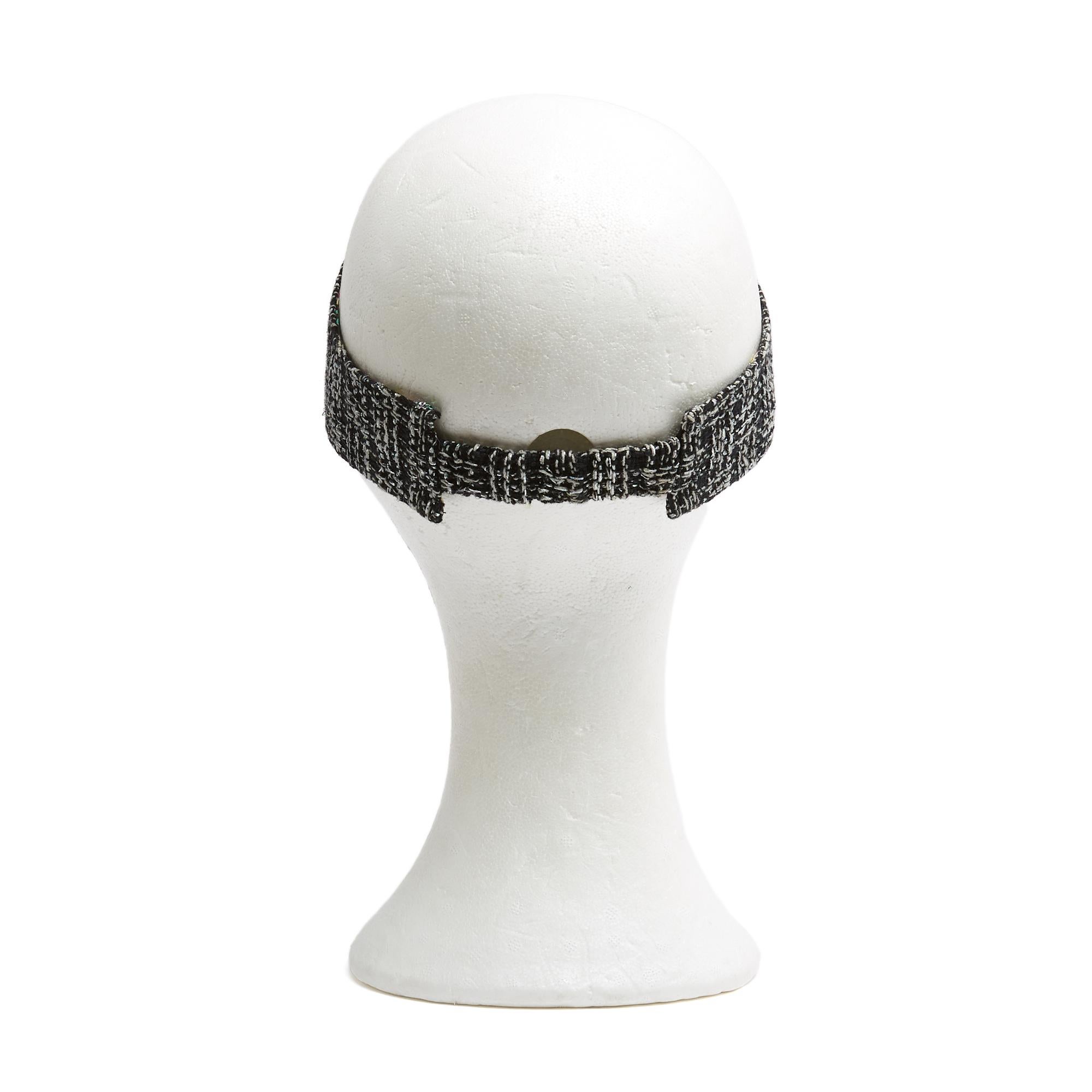 Reversible Chanel visor in black tweed with white flecks on one side and black cotton canvas (?) with Chanel logos in all colors, elastic band (probably an M). The visor is in excellent condition and has a great worn look.