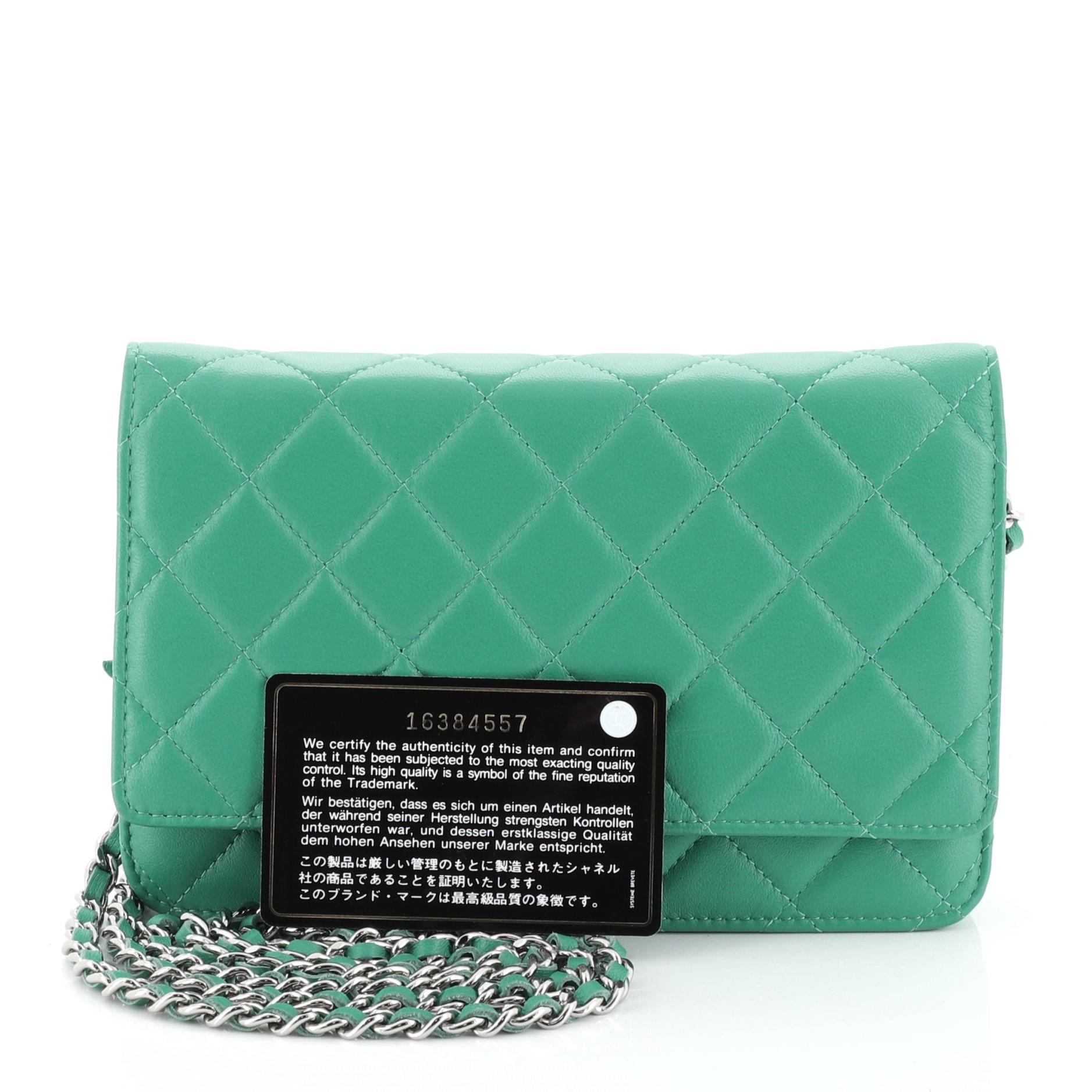 This Chanel Wallet on Chain Quilted Lambskin, crafted in green quilted lambskin leather, features woven-in leather chain strap, front flap with CC logo, exterior back slip pocket, and silver-tone hardware. Its magnetic snap button closure opens to a