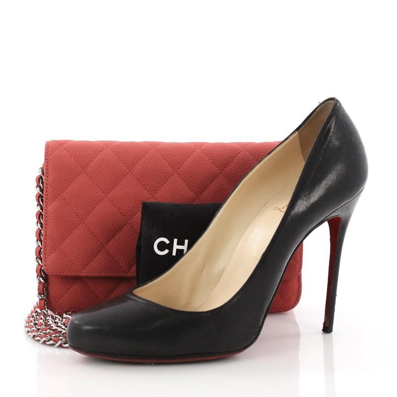 This Chanel Wallet on Chain Quilted Caviar, crafted in red quilted caviar leather, features woven-in leather chain strap, front flap with CC logo, and gold-tone hardware. Its magnetic snap button closure opens to a red fabric interior with multiple