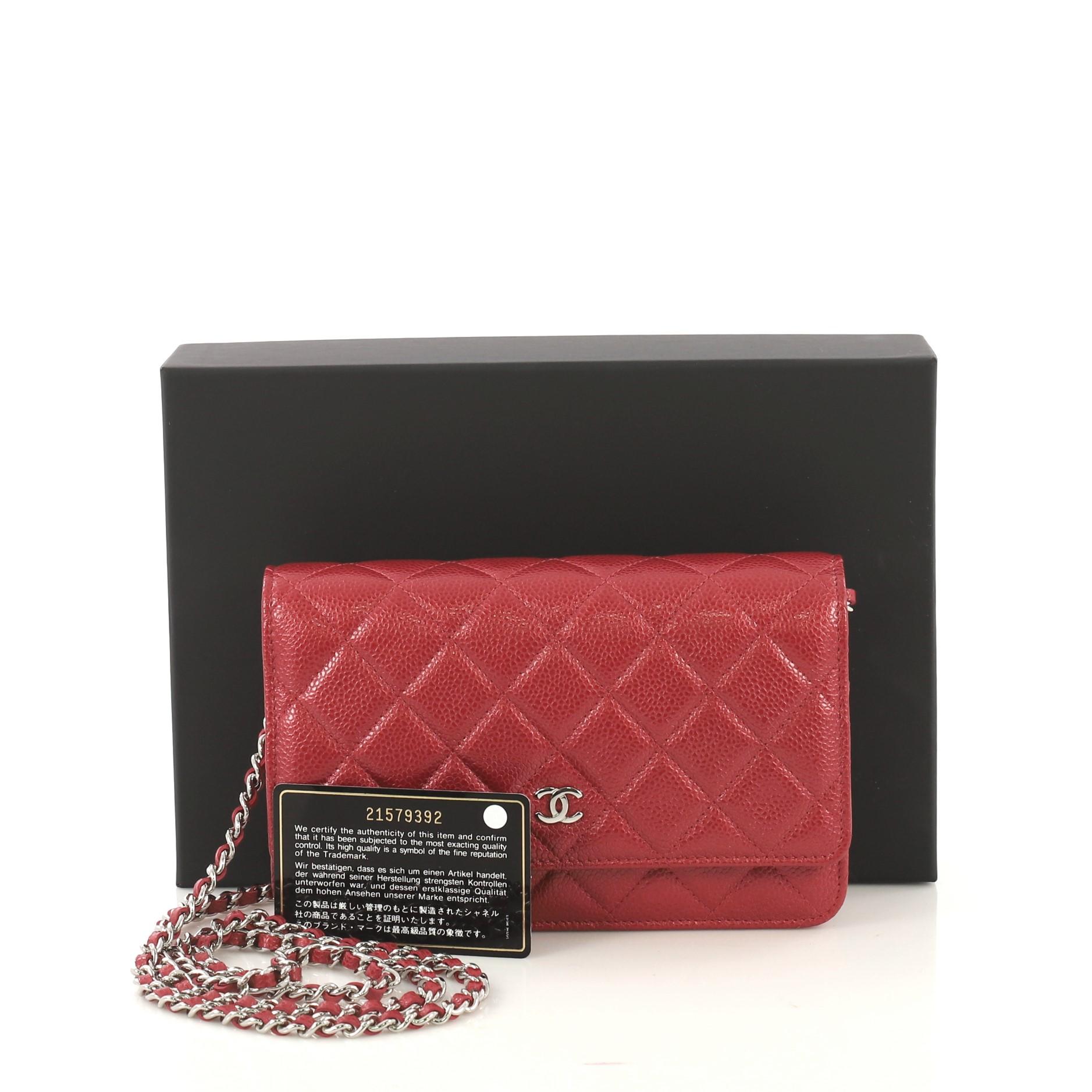 This Chanel Wallet on Chain Quilted Caviar, crafted in red quilted caviar leather, features woven-in leather chain strap, front flap with CC logo, exterior back slip pocket, and silver-tone hardware. Its magnetic snap button closure opens to a red