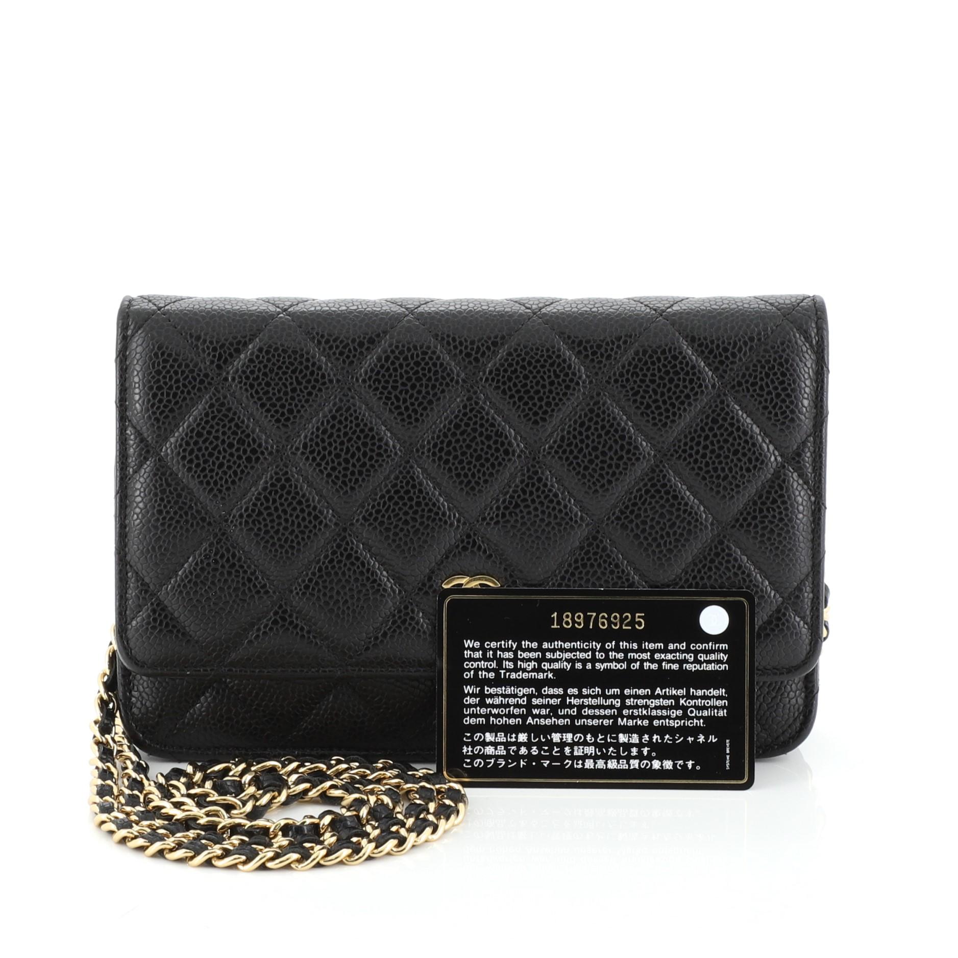 This Chanel Wallet on Chain Quilted Caviar, crafted in black quilted caviar leather, features woven-in leather chain strap, front flap with CC logo, exterior back slip pocket, and gold-tone hardware. Its magnetic snap button closure opens to a red