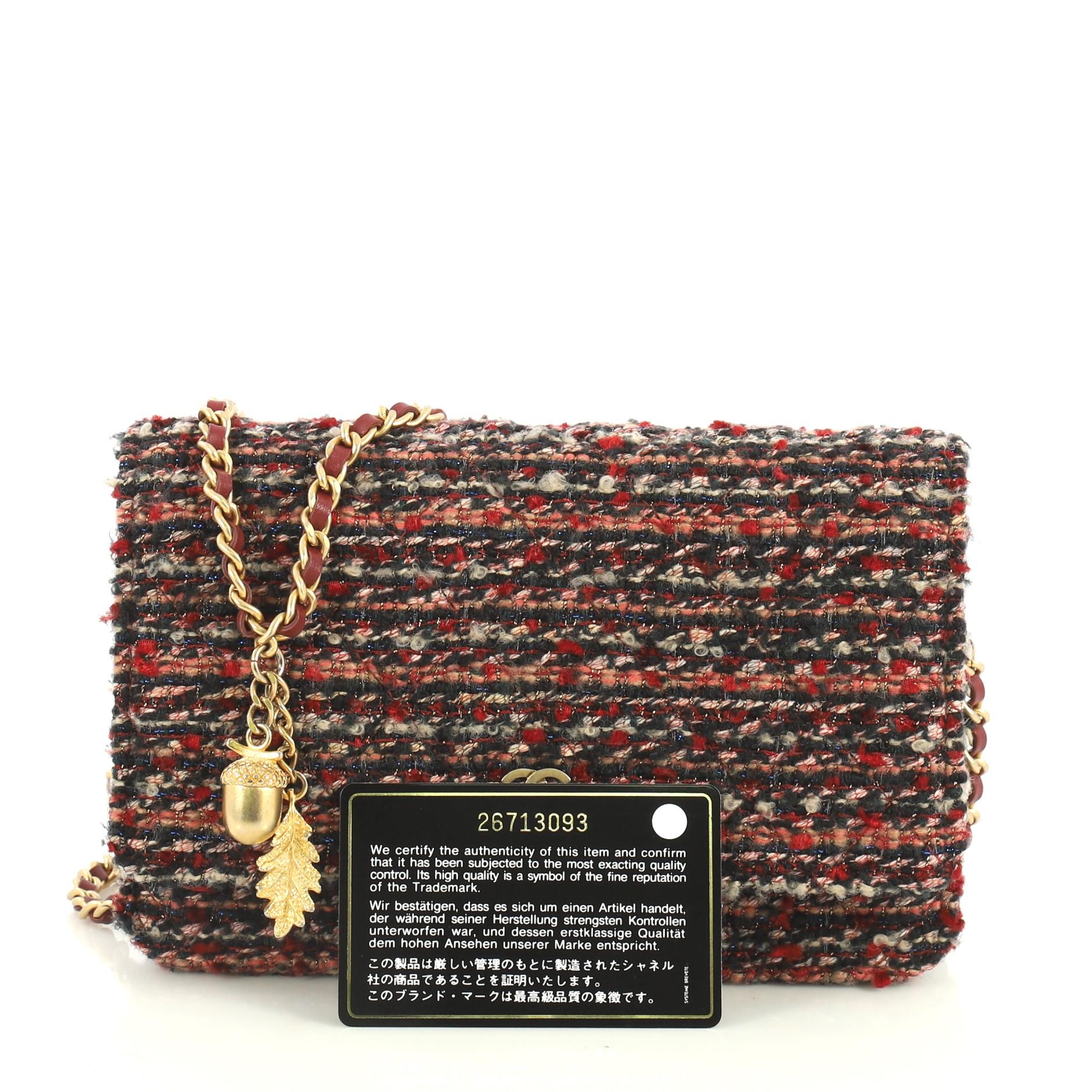 This Chanel Wallet on Chain Tweed, crafted in red multicolor tweed, features woven-in leather chain strap, front flap with CC logo, and gold-tone hardware. Its magnetic snap button closure opens to a red fabric and leather interior with multiple