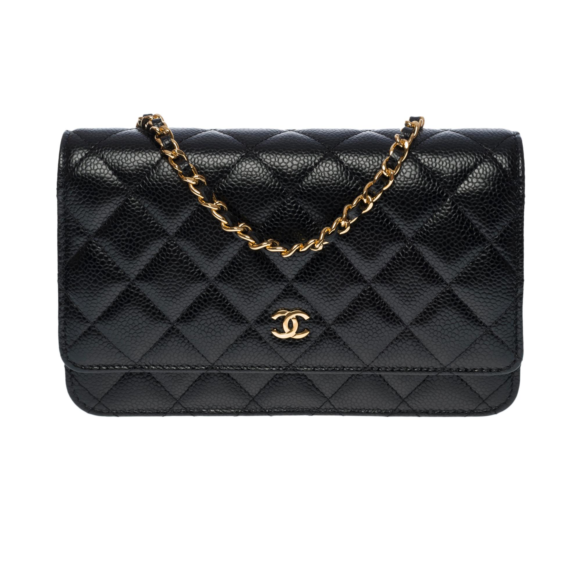 Lovely Chanel Wallet On Chain (WOC) shoulder bag in black caviar quilted leather, gold-plated metal hardware, a gold-plated metal chain handle interwoven with black leather for a shoulder and crossbody carry


Gold Metal Flap Closure
A patch pocket
