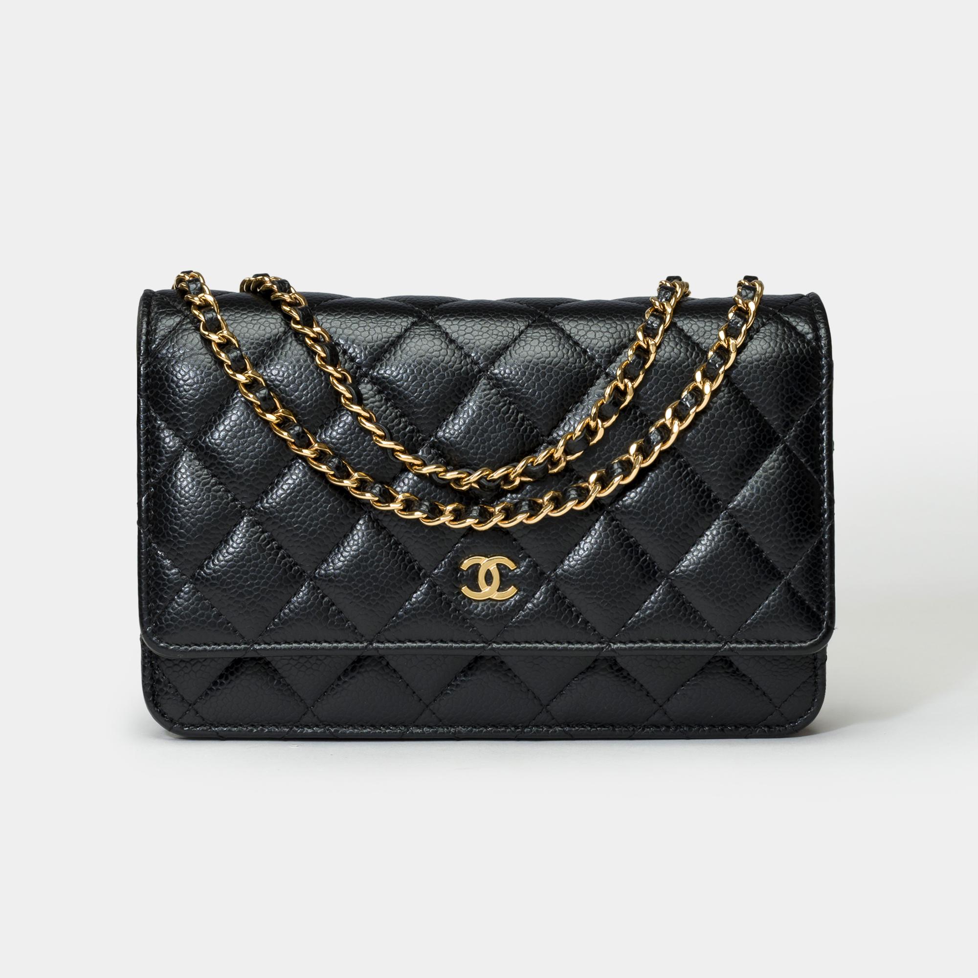 Superb Chanel Wallet On Chain (WOC) shoulder bag in black caviar quilted leather, gold metal trim, a gold metal chain handle interlaced with black leather allowing a shoulder or crossbody carry

A patch pocket on the back of the bag
Closure by flap,