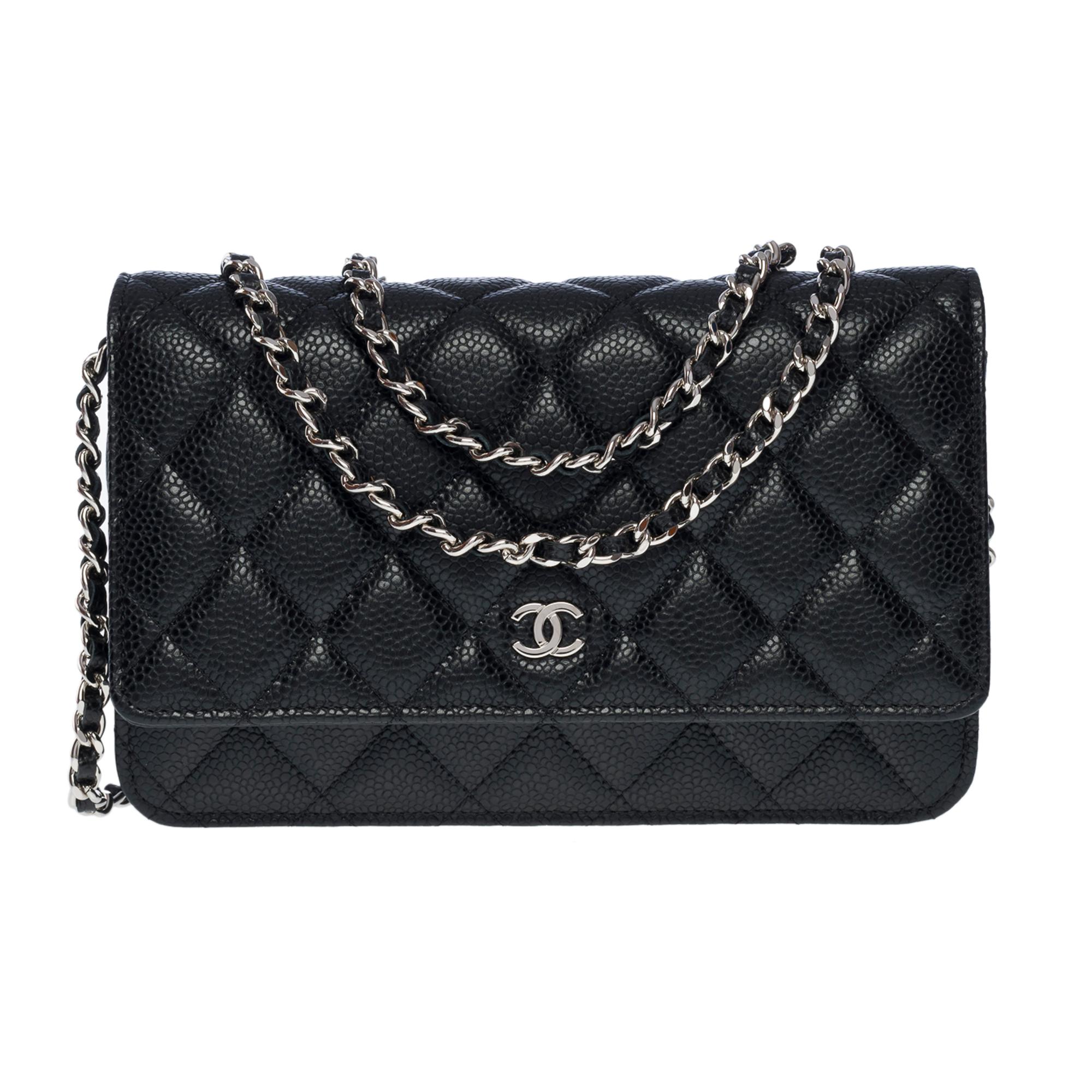 Lovely Chanel Wallet On Chain (WOC) shoulder bag in black caviar quilted leather, silver metal hardware, a gold-plated metal chain handle interwoven with black leather for a shoulder and crossbody carry


Gold Metal Flap Closure
A patch pocket at