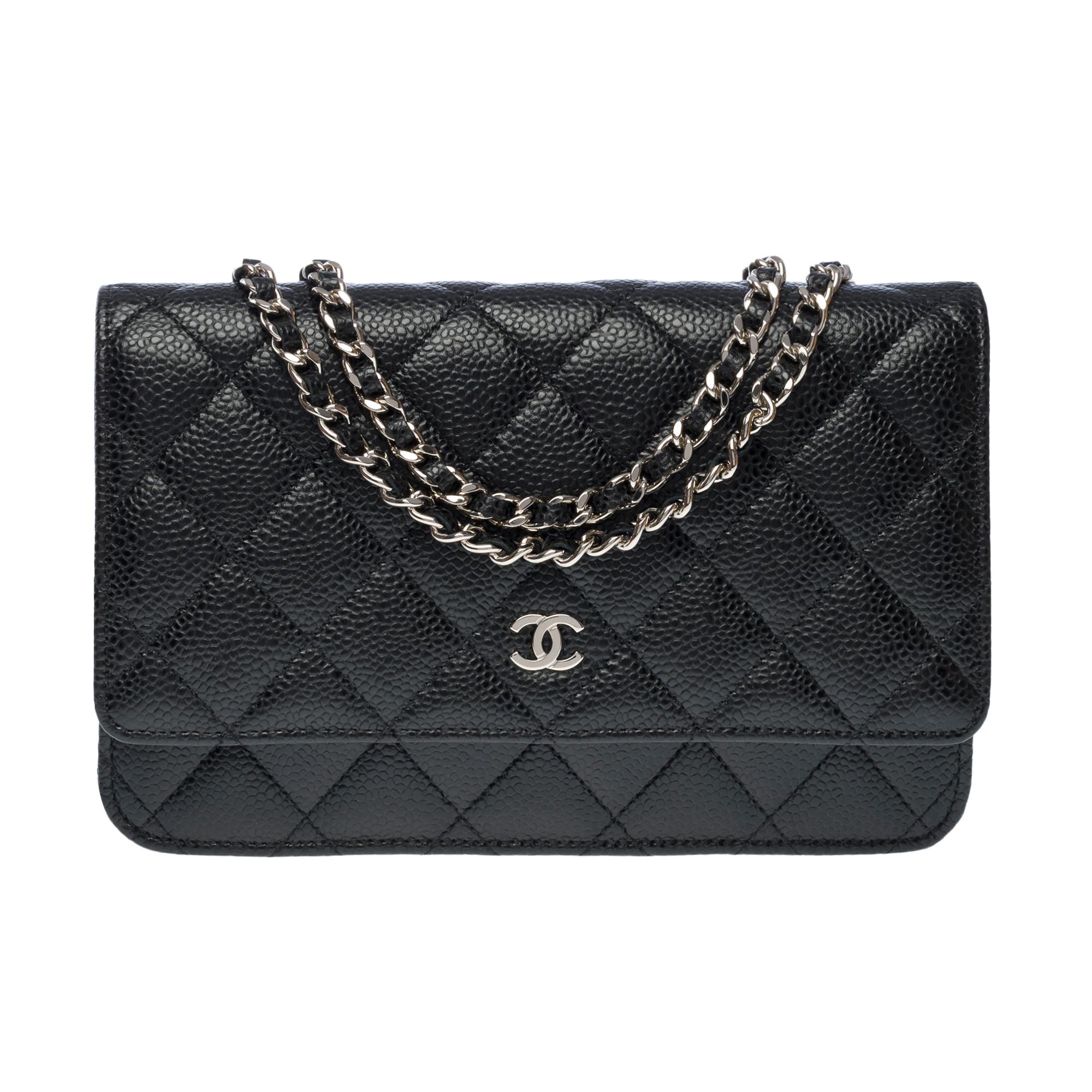 Lovely Chanel Wallet On Chain (WOC) shoulder bag in black caviar quilted leather, silver metal hardware, a silver metal chain handle interwoven with black leather for a shoulder and crossbody carry

Silver Metal Flap Closure
A patch pocket at the