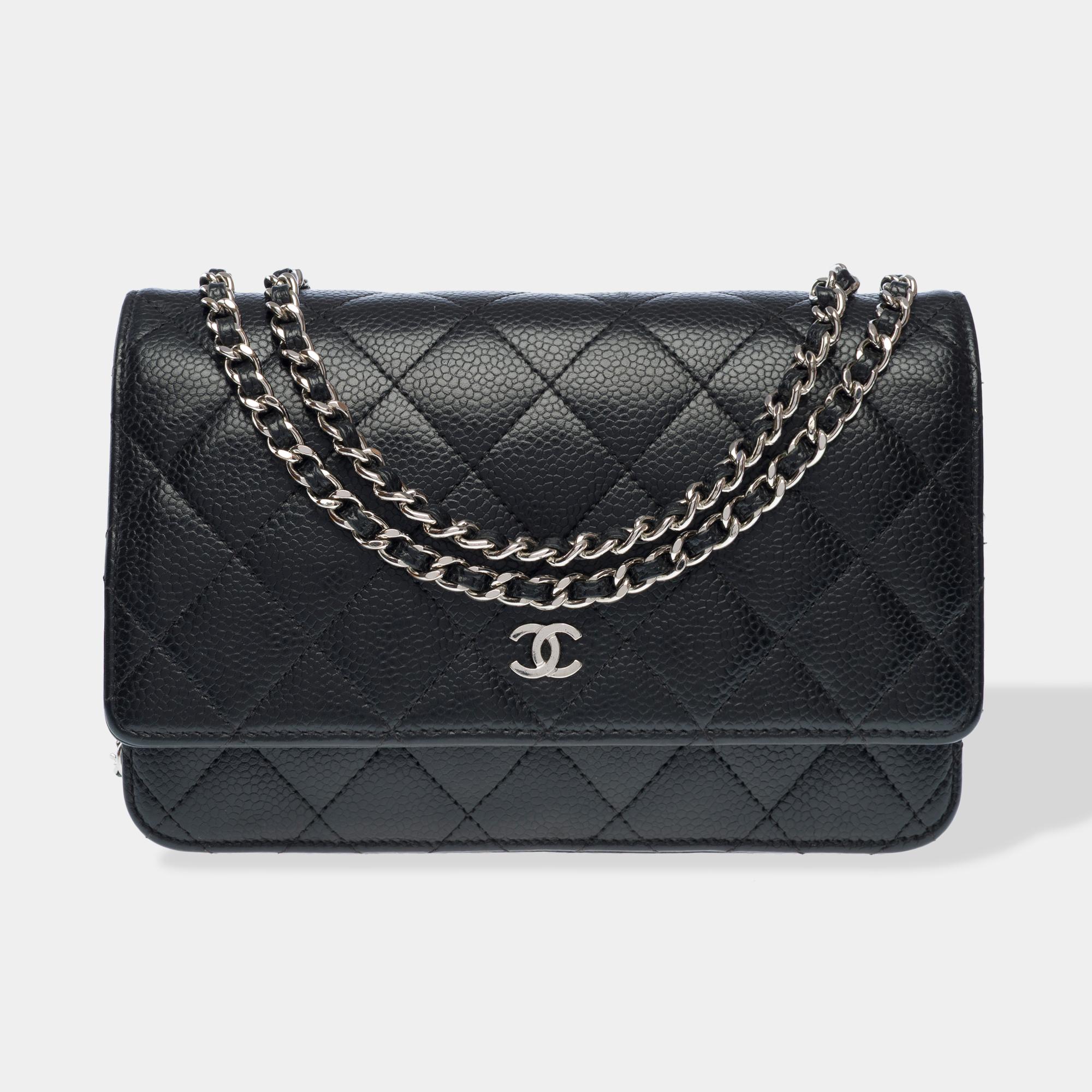 Superb​ ​Chanel​ ​Wallet​ ​On​ ​Chain​ ​(WOC)​ ​shoulder​ ​bag​ ​in​ ​black​ ​quilted​ ​caviar​ ​leather,​ ​silver-tone​ ​metal​ ​trim,​ ​a​ ​silver-tone​ ​metal​ ​chain​ ​strap​ ​interwoven​ ​with​ ​black​ ​leather​ ​one​ ​worn​ ​over​ ​the​