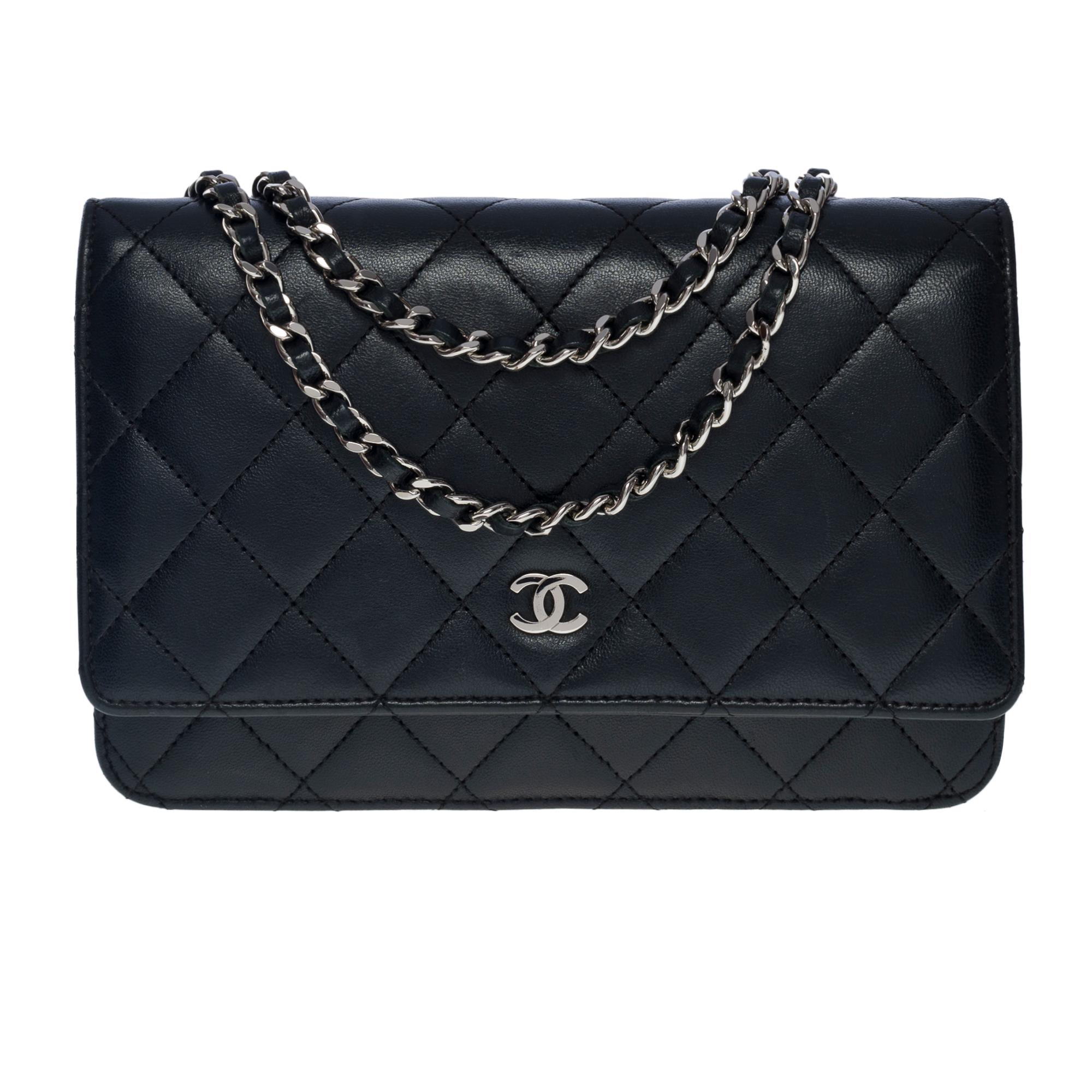 Lovely Chanel Wallet On Chain (WOC) shoulder bag in black quilted lambskin, silver metal hardware, a silver metal chain handle interwoven with black leather for a shoulder or crossbody carry
A patch pocket at the back of the bag
Closure by flap, CC