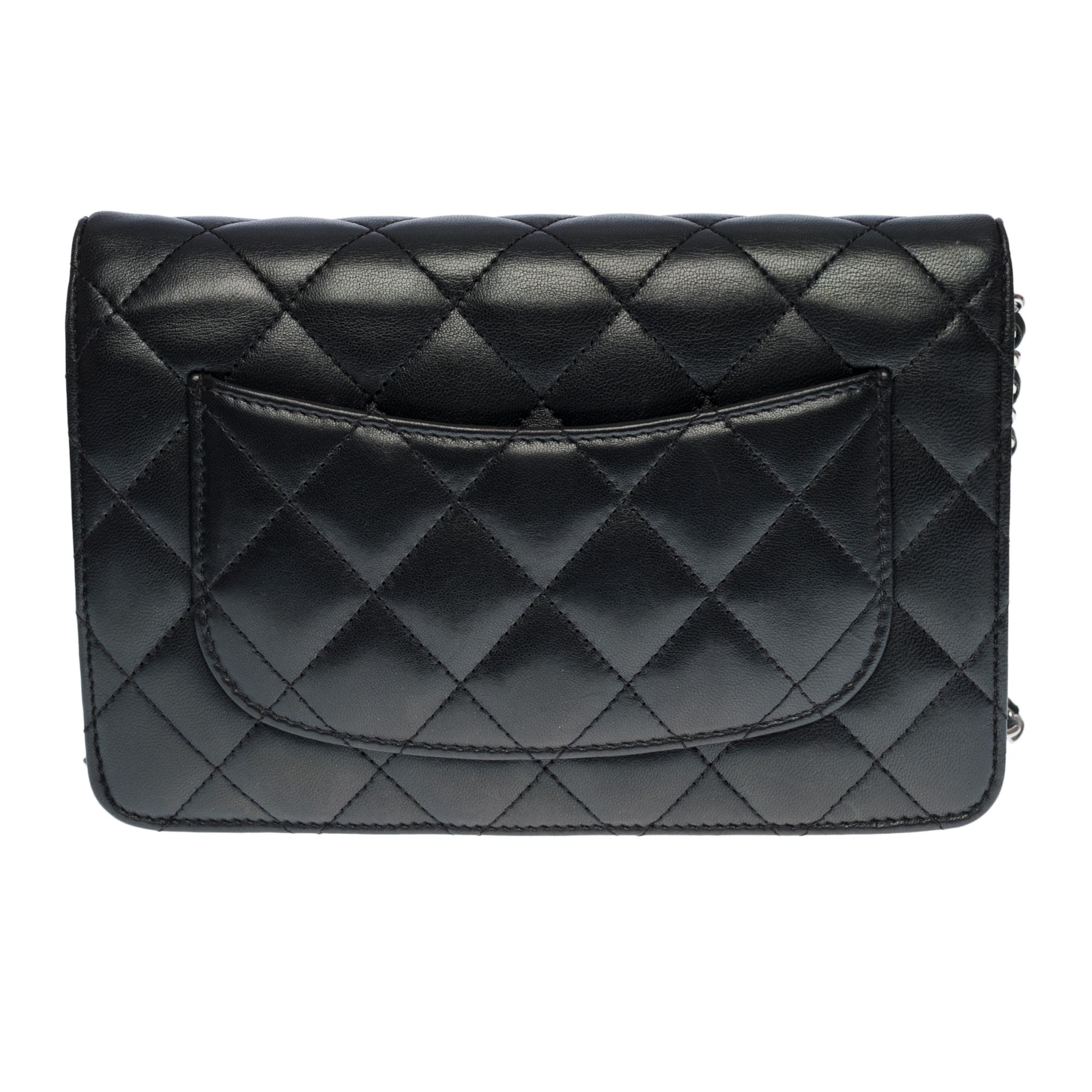 Lovely Chanel Wallet On Chain (WOC) bag in black quilted leather, silver metal hardware, a silver metal chain-handle interwoven with black leather for a shoulder and crossbody support


Silver metal flap closure
A patch pocket at the back of the