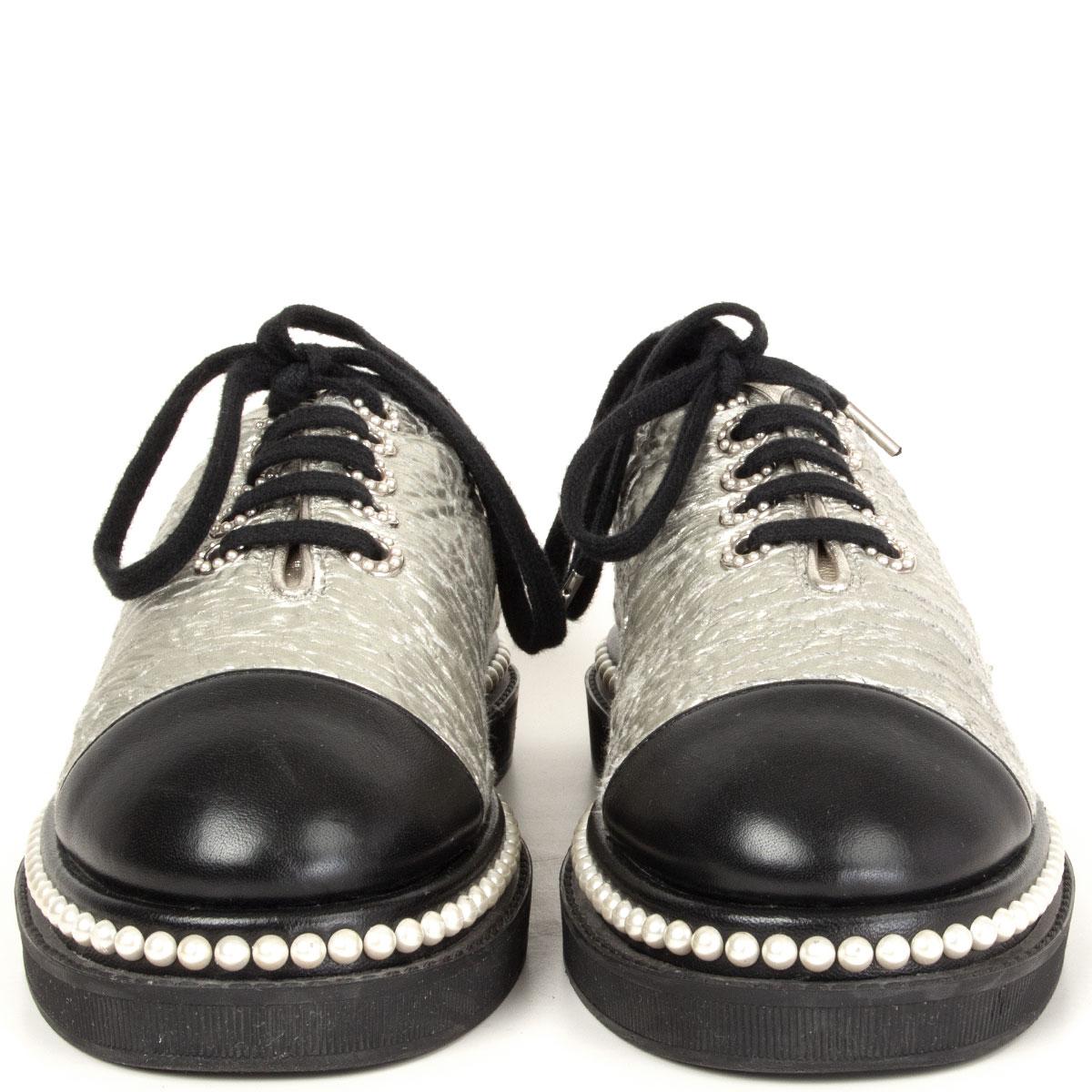 100% authentic Chanel dress shoes in warm silver and black smooth lambskin. Heel with CC logo pearl embellishment and eyelets. They flaunt faux pearl trim on the midsoles and come equipped with leather lined insoles and solid rubber soles. Have been
