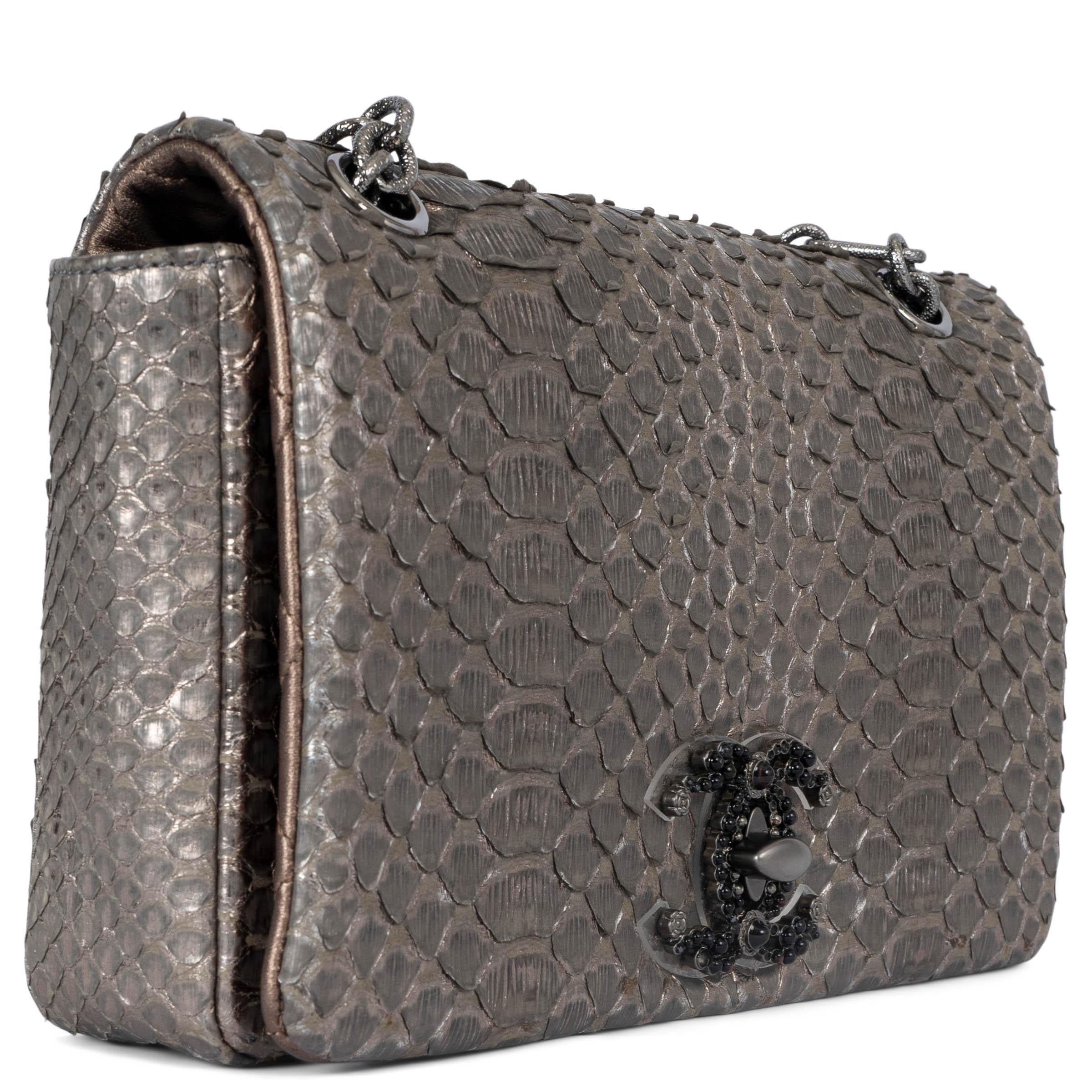 100% authentic Chanel Medium Flap bag in warm silver python featuring black beaded CC embellished turnlock on the front, patch pocket on the back and ruthenium textured chain shoulder strap. Lined in bronze quilted lambskin with one zipper pocket