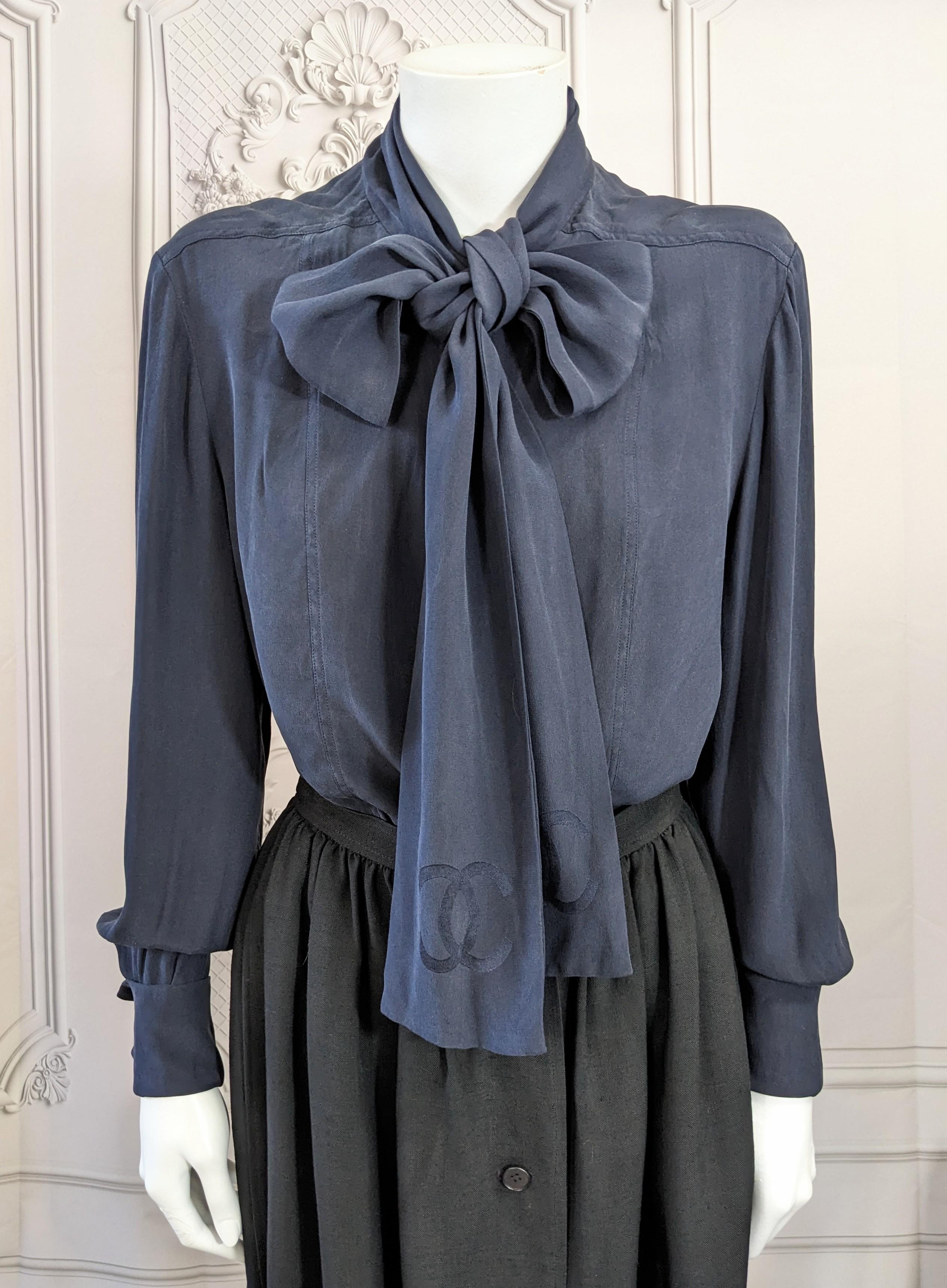 Klassische Chanel Navy Washed Silk Crepe Satin Logo Pussy Bow Bluse aus den 1980er Jahren. Kühler, weicher Stoff aus sandgewaschenem Seidenkrepp mit einer Innenseite aus Satin. So kann das CC-Logo auf den Seidenkrawatten in den Stoff eingewebt