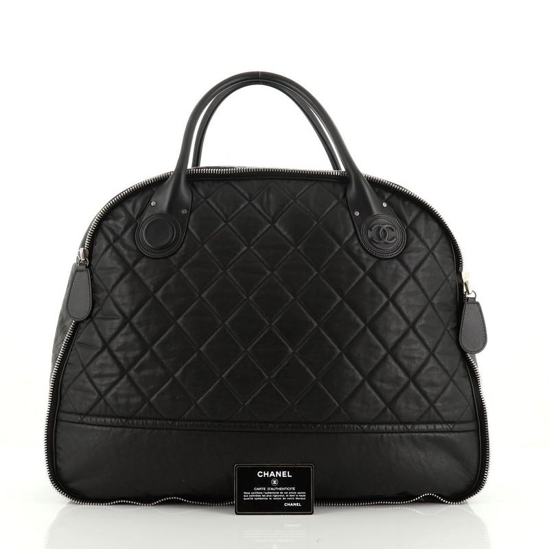 This Chanel Weekender Bag Quilted Coated Canvas Horizontal, crafted in black quilted coated canvas, features dual rolled leather handles with embossed CC logo detailing, zip around details for expansion and silver-tone hardware. Its zip closure